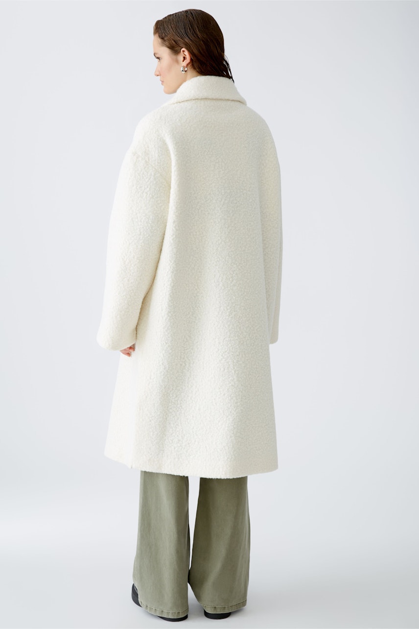 Cozy winter coat: A woman in a soft white coat with a relaxed fit, perfect for chilly days.