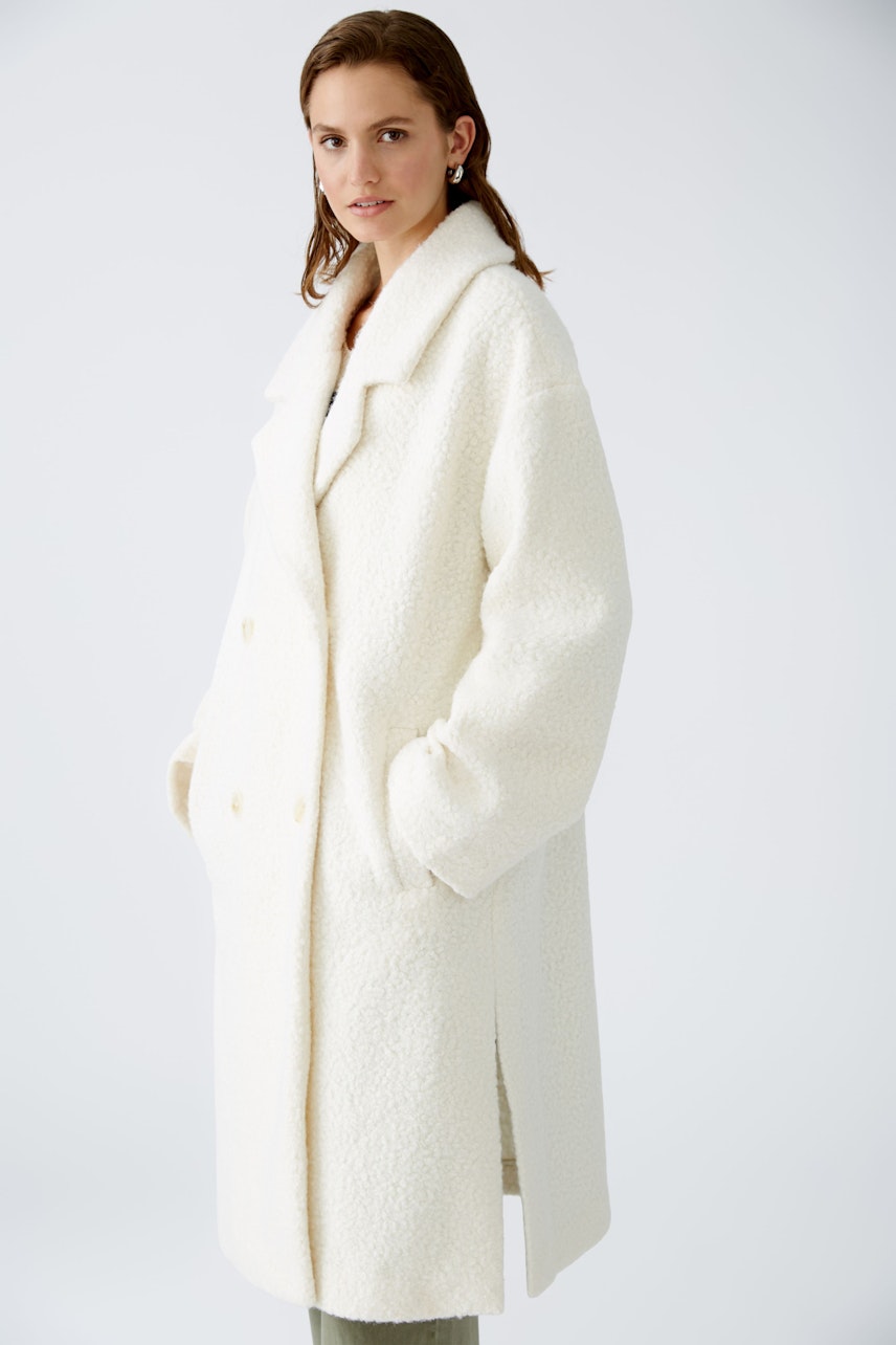 Stylish women's winter coat: A woman in a cozy white coat with a relaxed fit and large buttons.