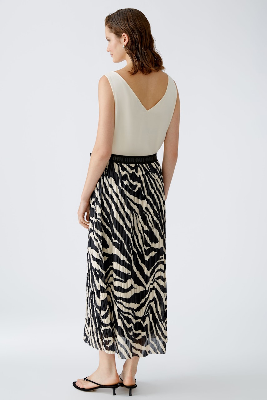 Elegant maxi skirt: Woman in a stylish black and white striped maxi skirt, showcasing a chic design.