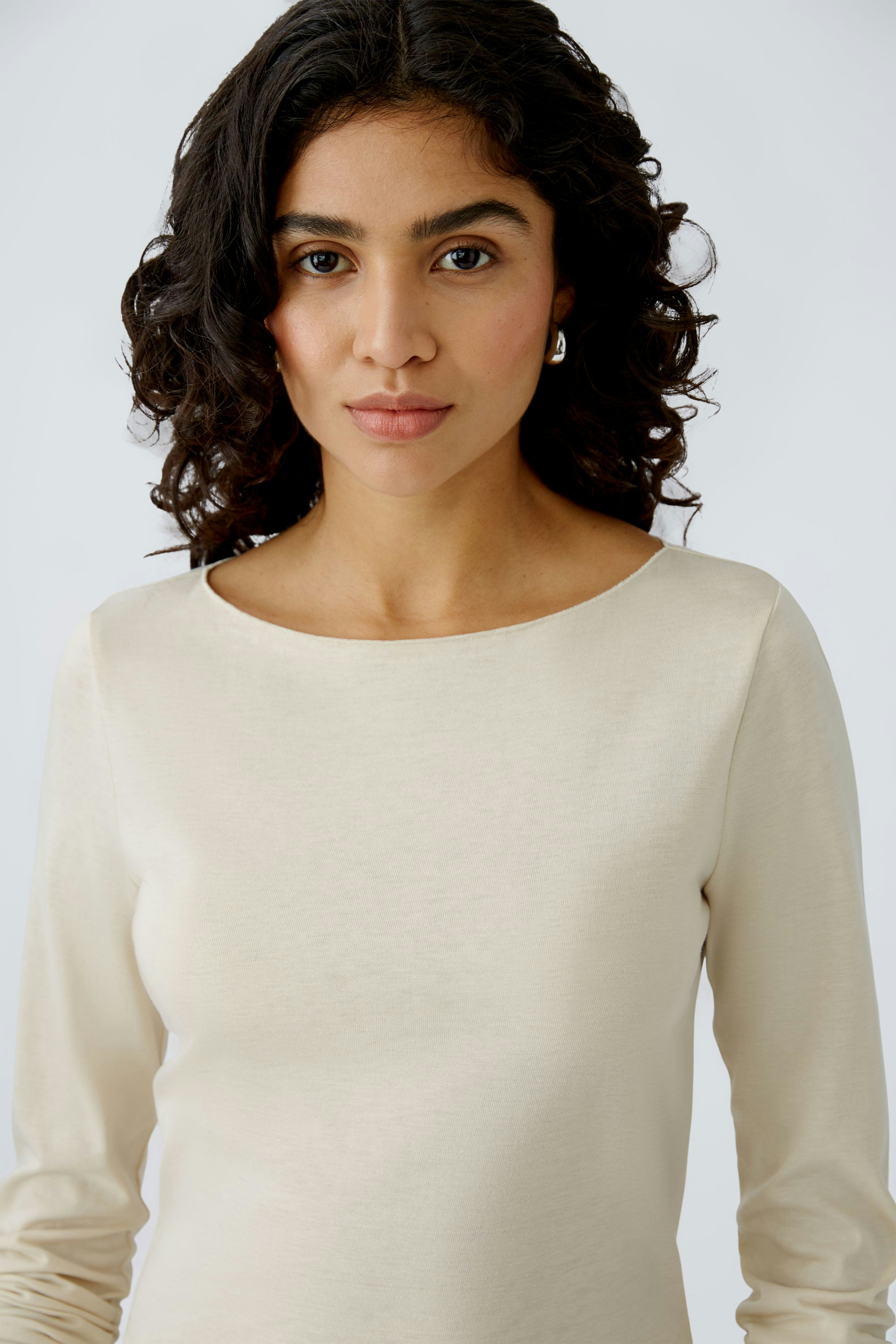 Elegantes Damen-T-Shirt: Frau in cremefarbenem, schlichten T-Shirt mit Rundhalsausschnitt.