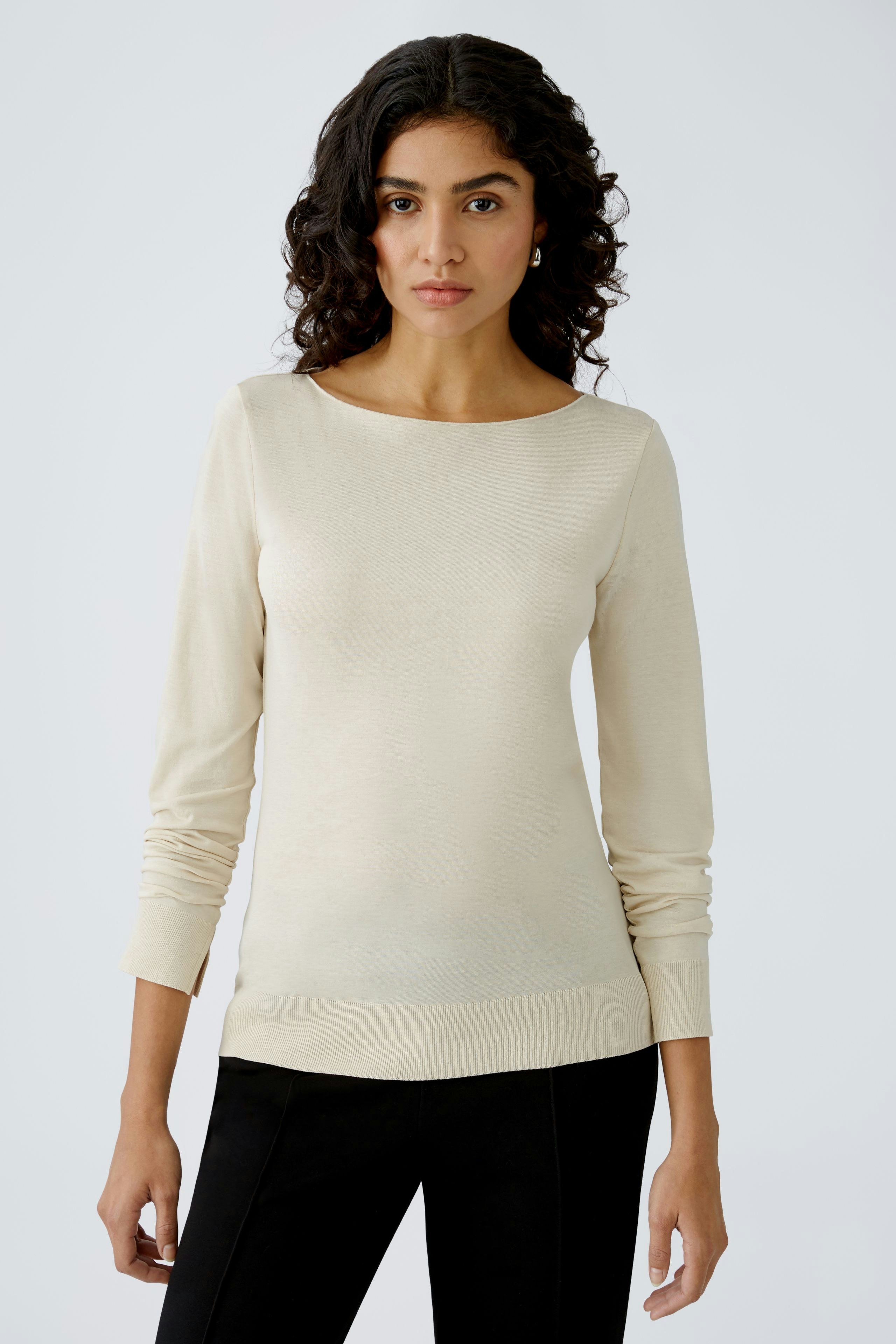 Beige Damen-T-Shirt: Frau in schlichter, eleganter Bluse mit langen Ärmeln und Rundhalsausschnitt.