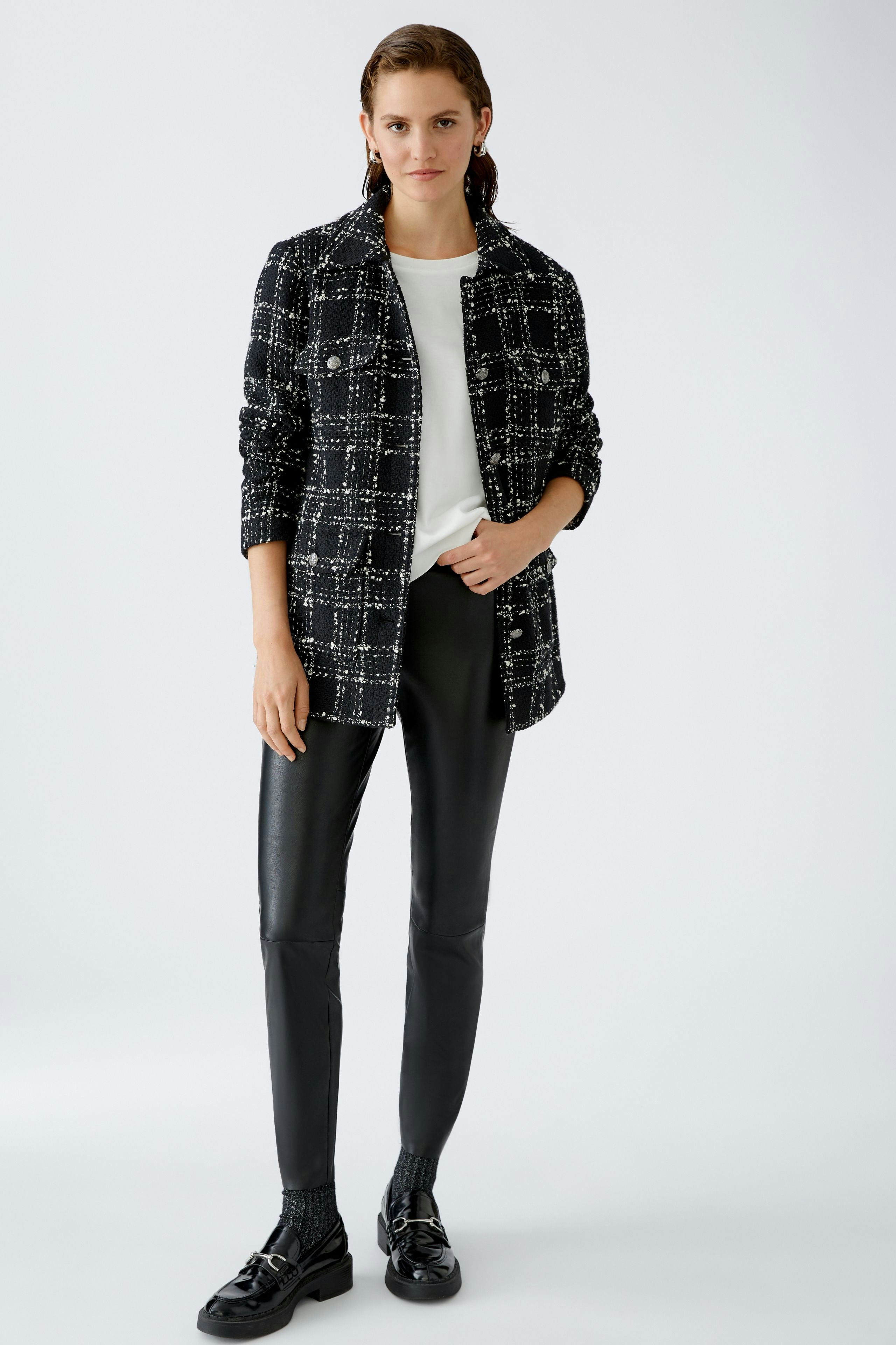 Stylish women's T-shirt: A woman in a white T-shirt paired with a chic black and white blazer.