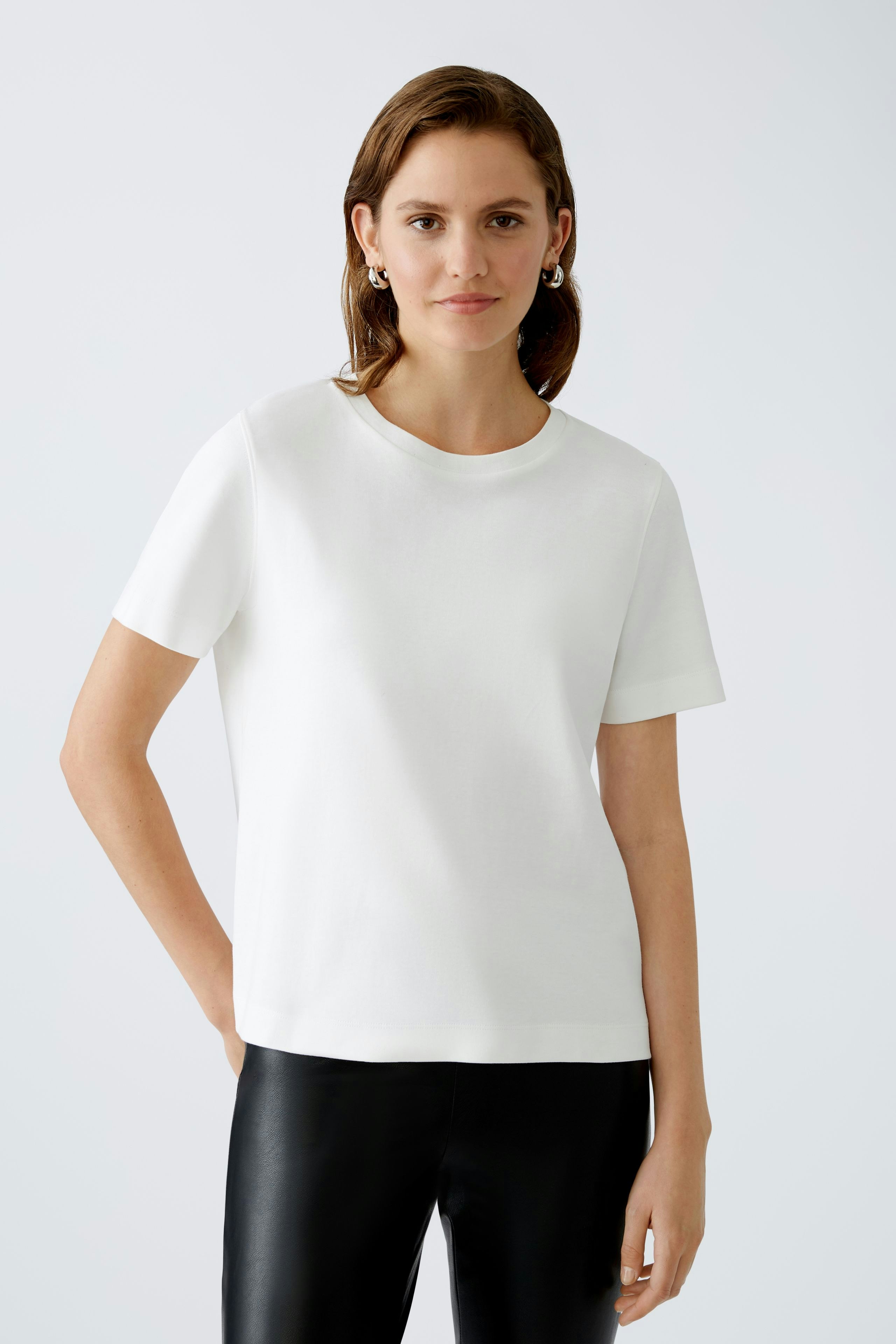 Stylish women's T-shirt: A woman in a white short-sleeve top, exuding casual elegance.