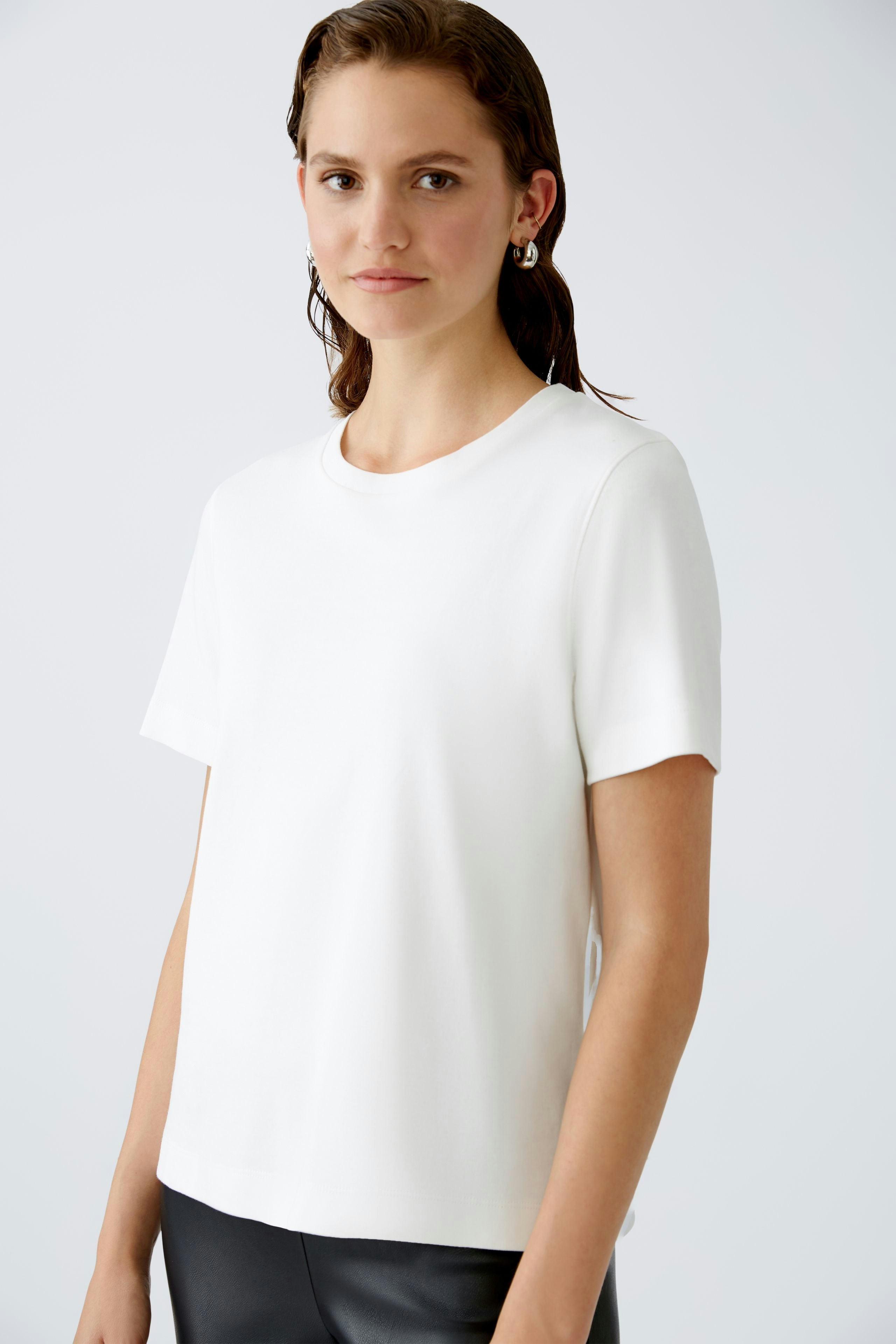 Stylish women's T-shirt: A woman in a white short-sleeve top, exuding casual elegance.