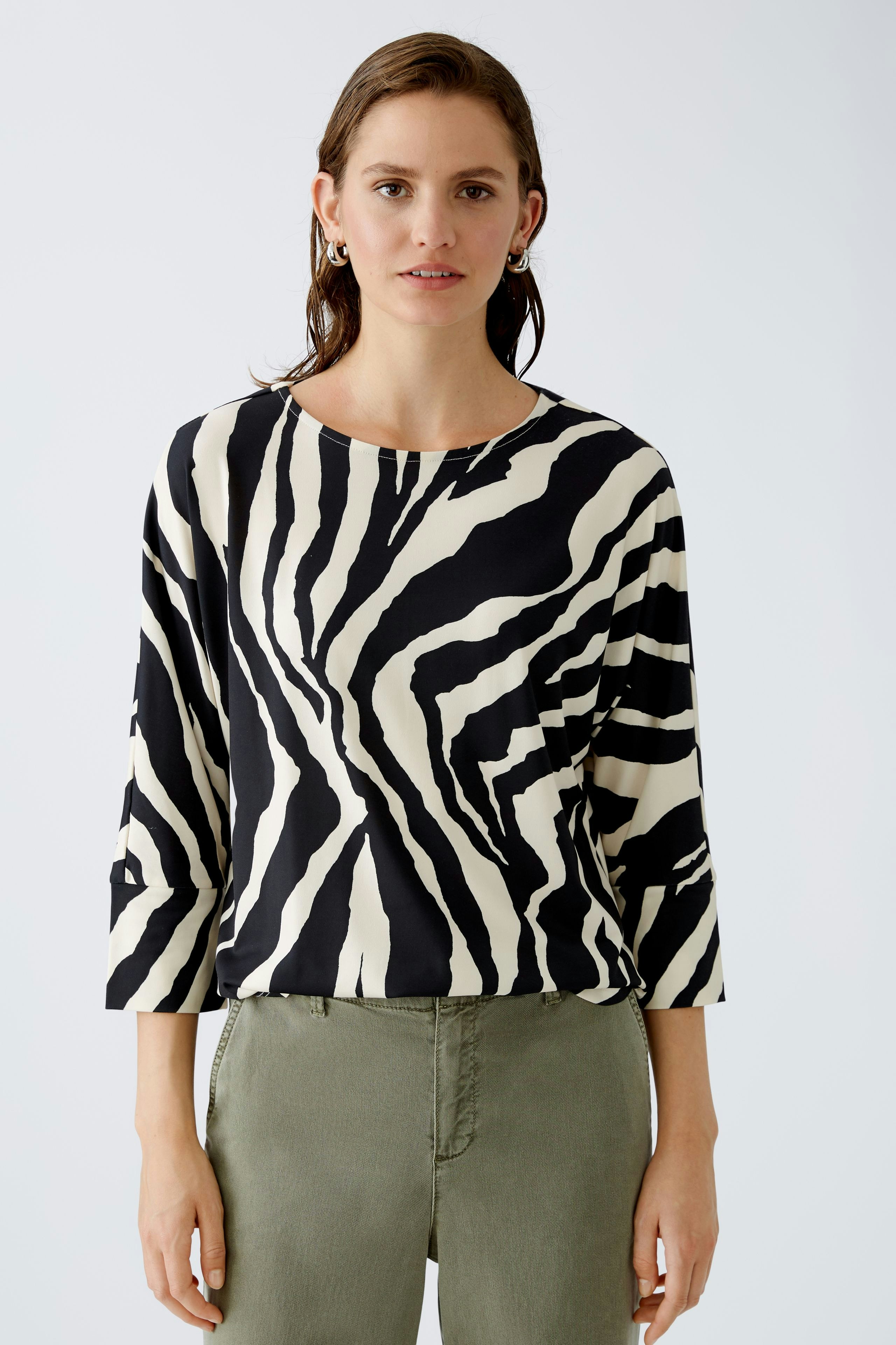 Stylish women's T-shirt: A woman in a black and white striped top, exuding modern elegance.