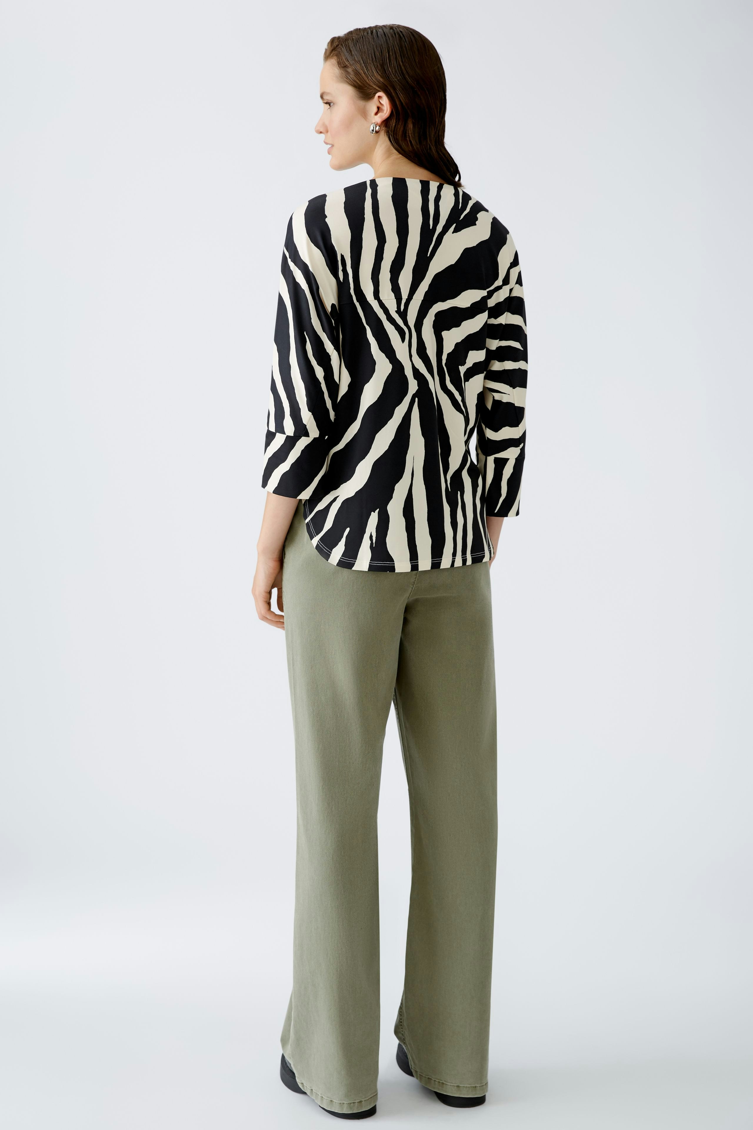 Stylish women's T-shirt: A woman in a black and white striped top with three-quarter sleeves.