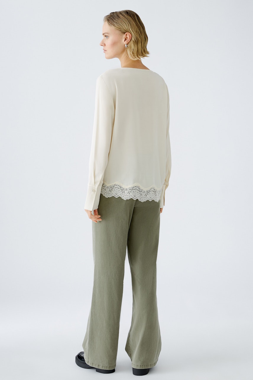 Elegant women's blouse with lace detail, worn by a woman, showcasing a stylish back view.