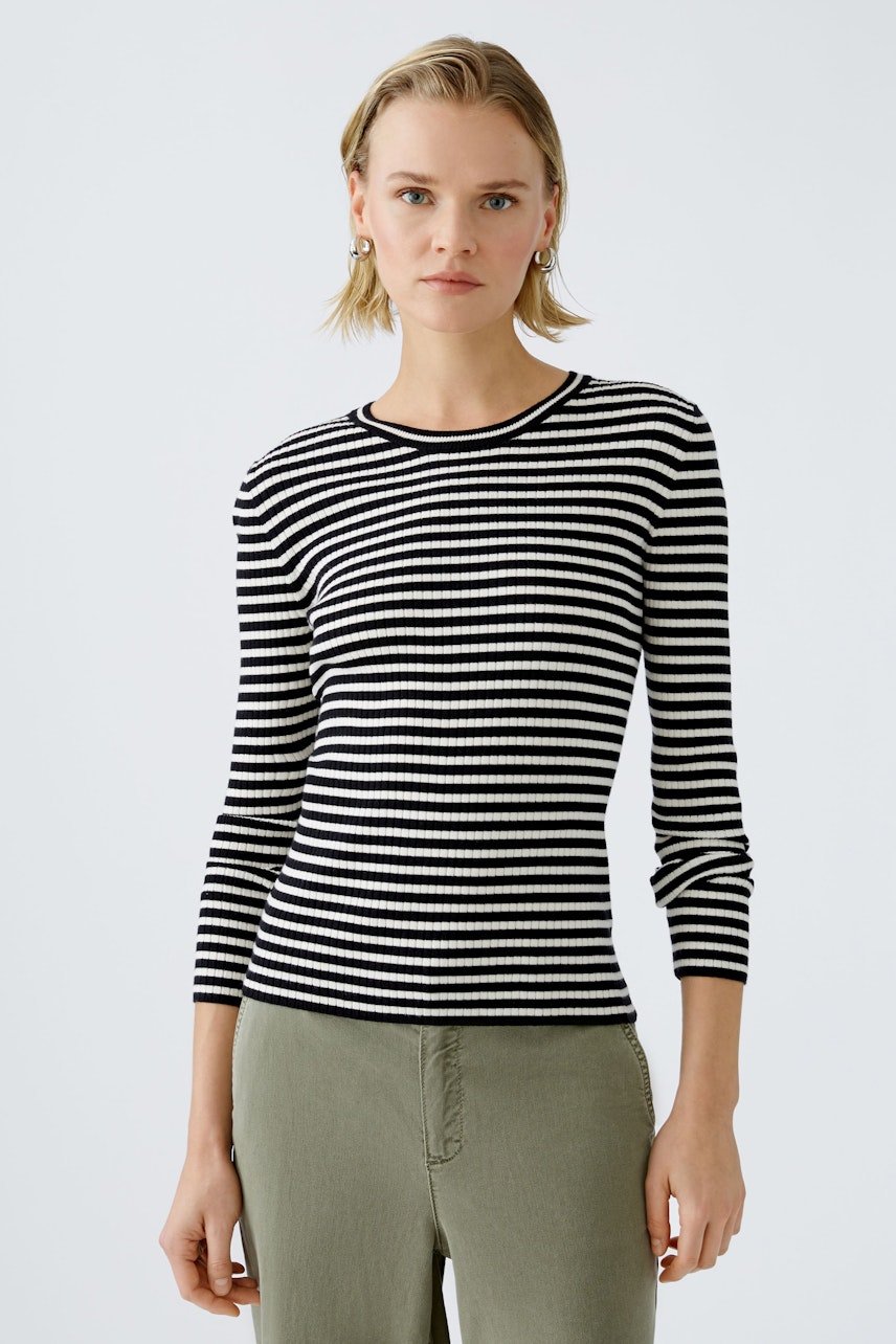 Modern women's pullover: A woman in a black and white striped pullover, exuding casual elegance.