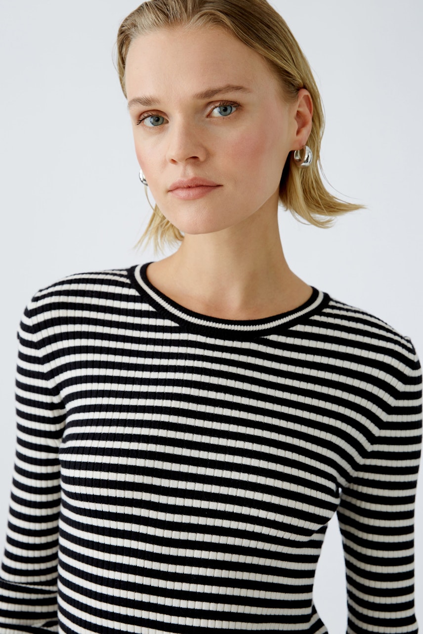 Modern women's pullover: A woman in a striped pullover with a classic round neckline.