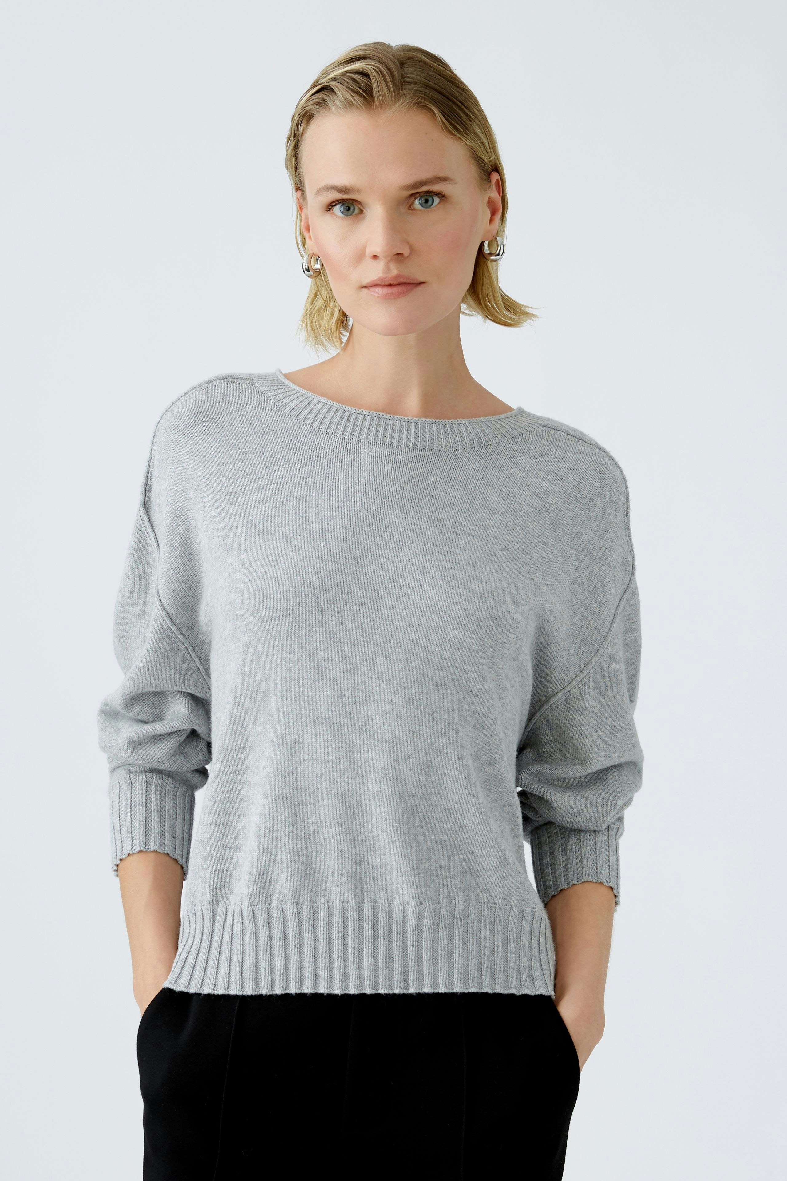 Eleganter Damen-Pullover in Grau: Frau mit lässigem Look und weichem Strickmaterial.