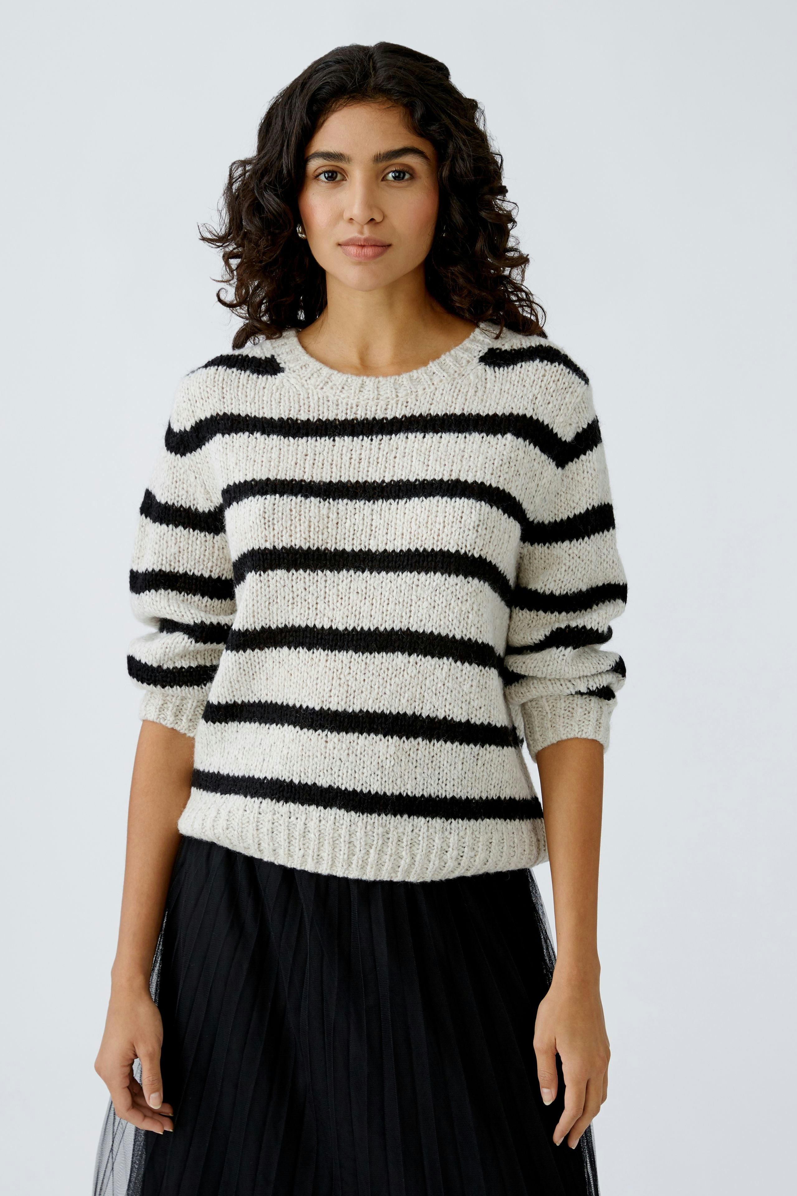 Damen-Pullover: Frau in gestreiftem Pullover mit lässigem Schnitt und Rundhalsausschnitt.