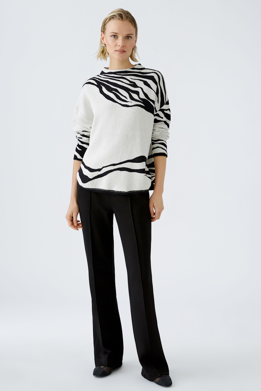 Stylish women's pullover: A woman in a black and white striped pullover paired with sleek trousers.