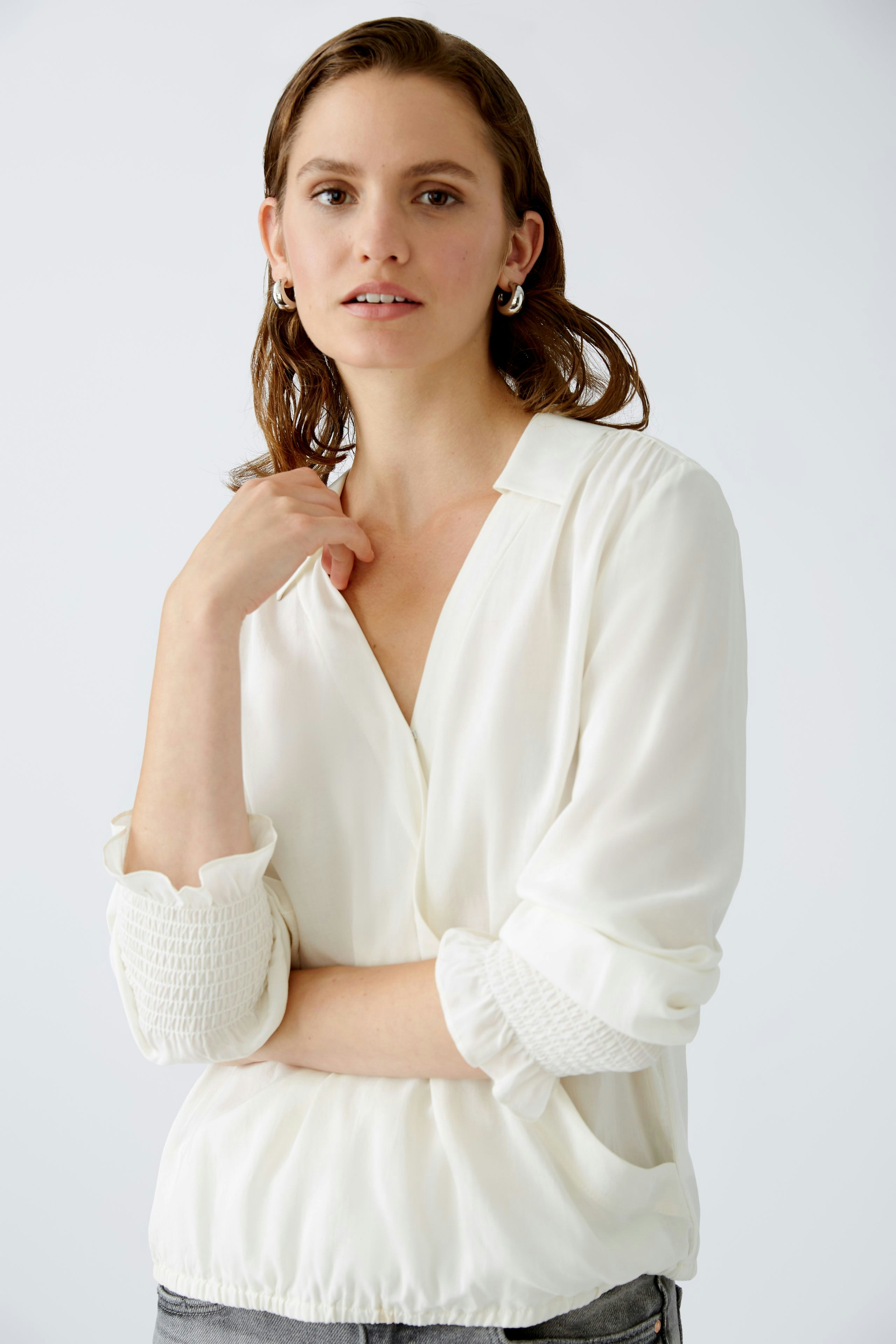 Elegant women's blouse: A woman in a white blouse with textured sleeves, exuding effortless style.