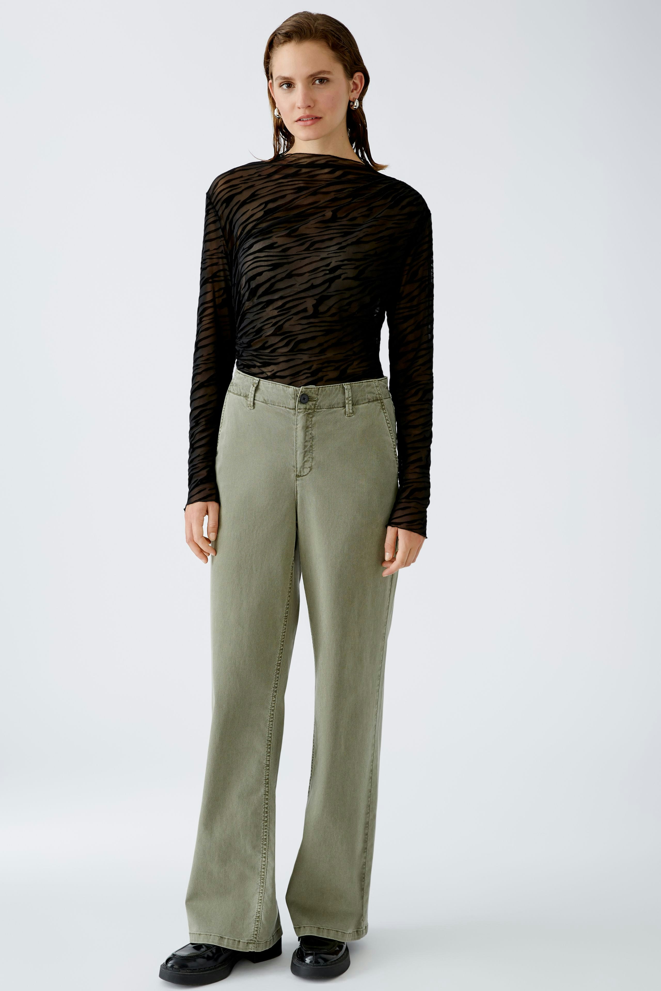 Stylish long-sleeve shirt: A woman in a black striped pullover paired with relaxed-fit pants.