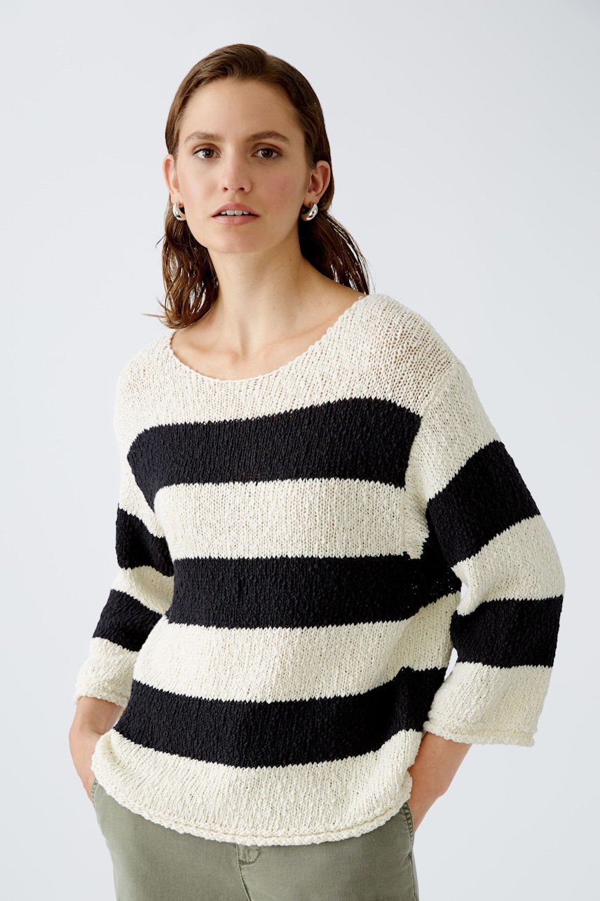 Stylish women's pullover: A woman in a striped pullover with a relaxed fit, perfect for casual outings.