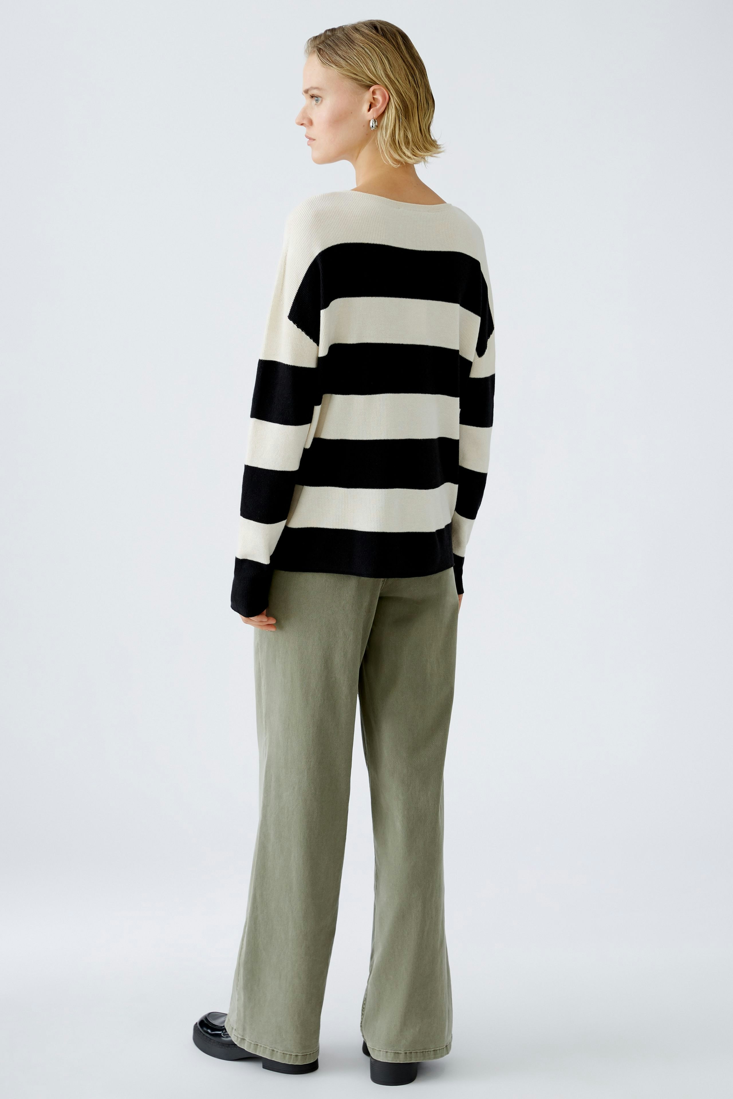 Damen-Pullover: Frau in gestreiftem Pullover mit lässigem Schnitt und bequemen Hosen.