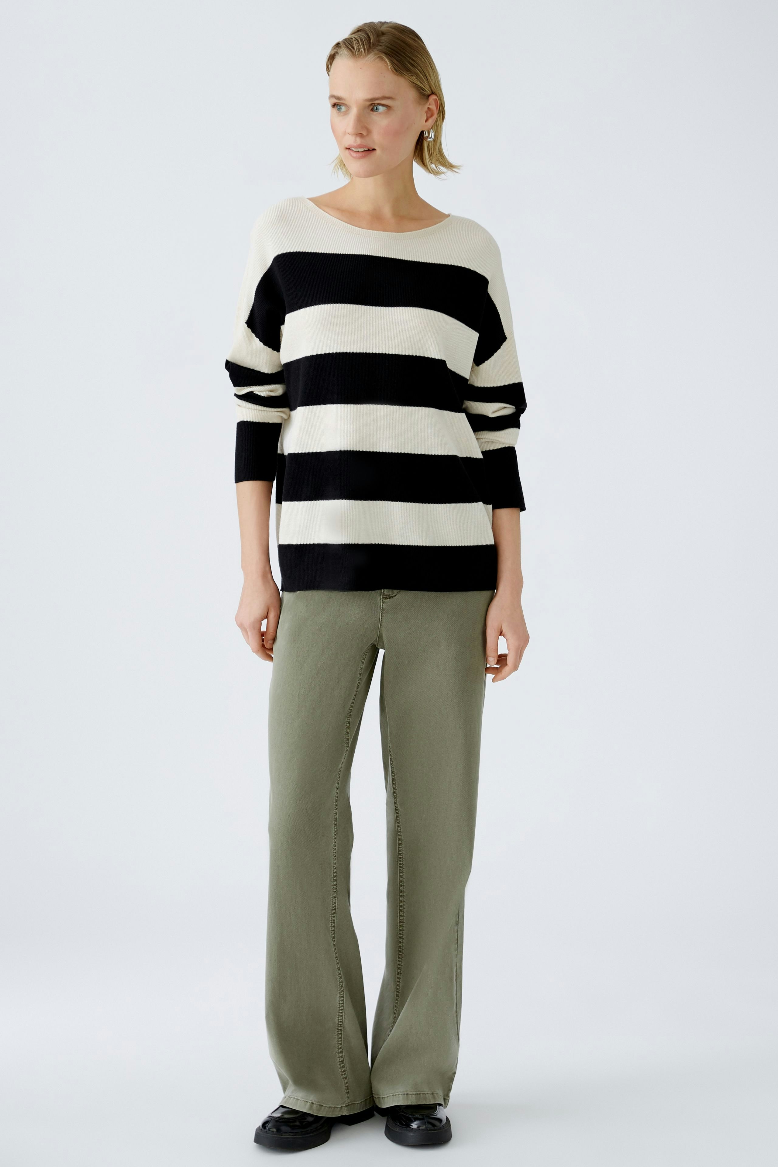 Damen-Pullover: Frau in gestreiftem Pullover mit lässigem Schnitt und bequemen Hosen.