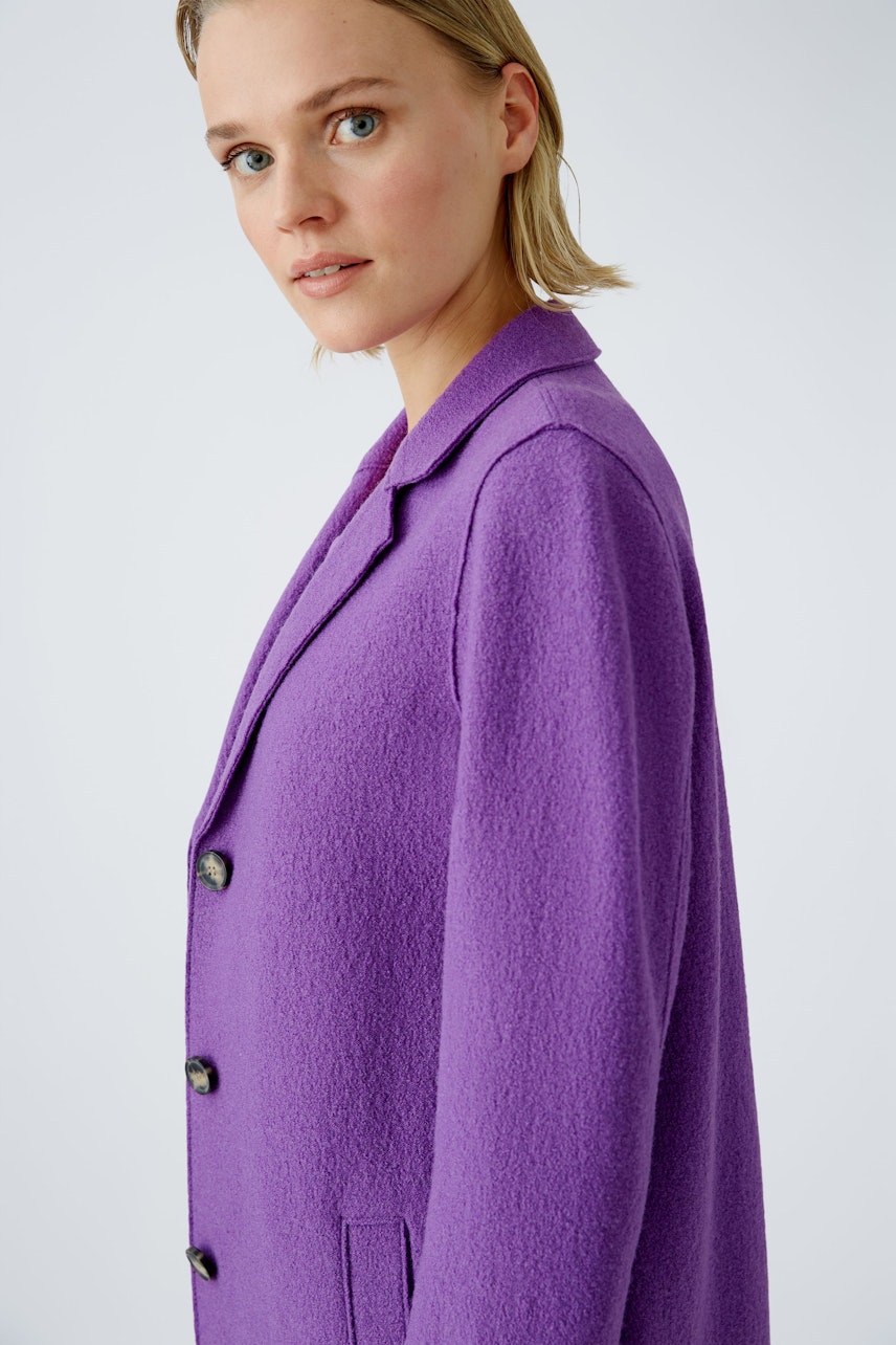 Stylish women's wool coat in vibrant purple, featuring a classic collar and button details.