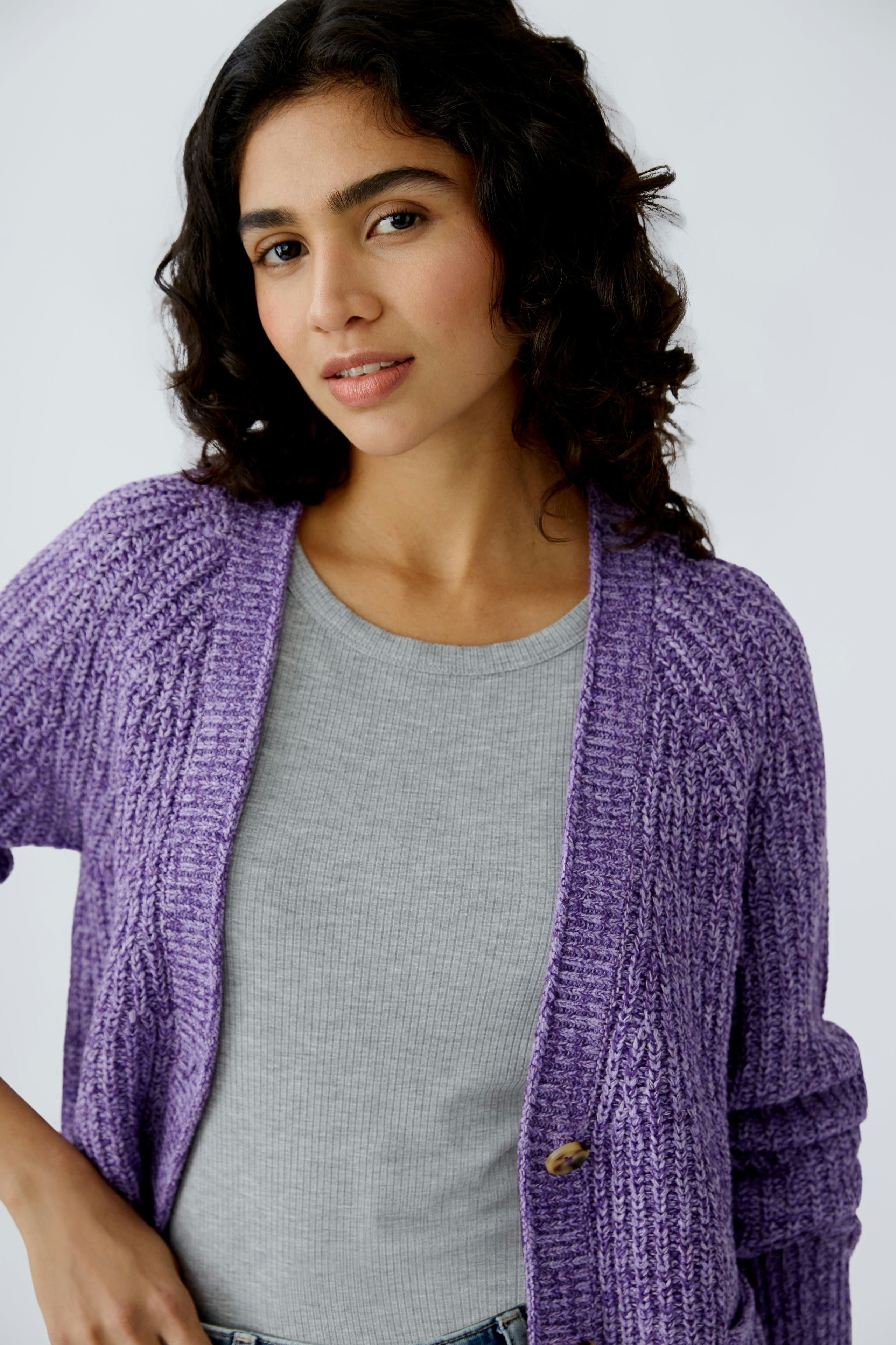 Stylish women's cardigan: A woman in a cozy purple cardigan over a gray top, exuding casual elegance.