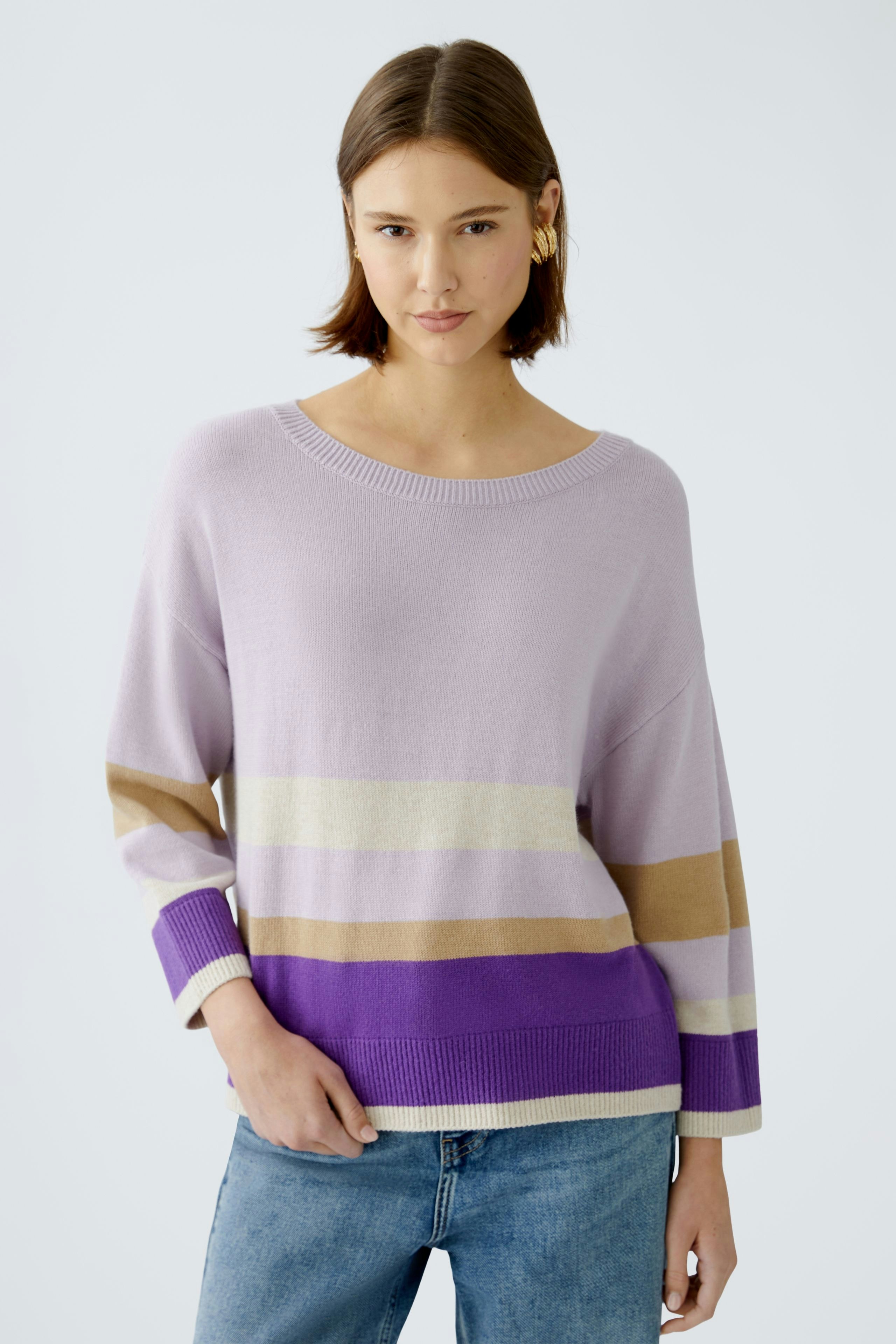 Damen-Pullover in sanften Farben: Frau trägt einen lässigen, gestreiften Pullover mit weitem Schnitt.