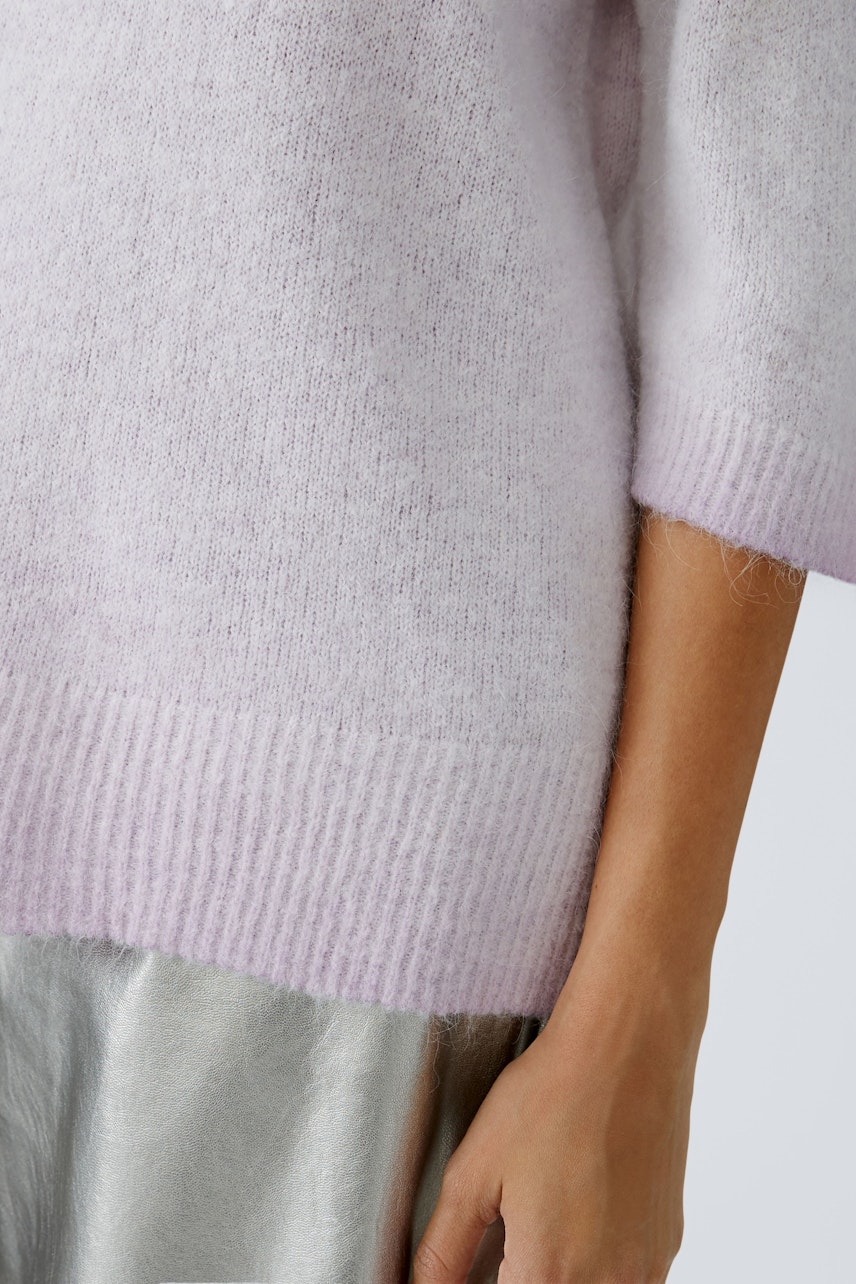 Soft lilac pullover: A woman showcases a cozy, lightweight pullover with a relaxed fit.