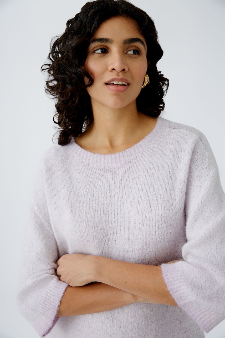 Modern women's pullover: A woman in a soft lilac pullover with three-quarter sleeves, smiling gently.