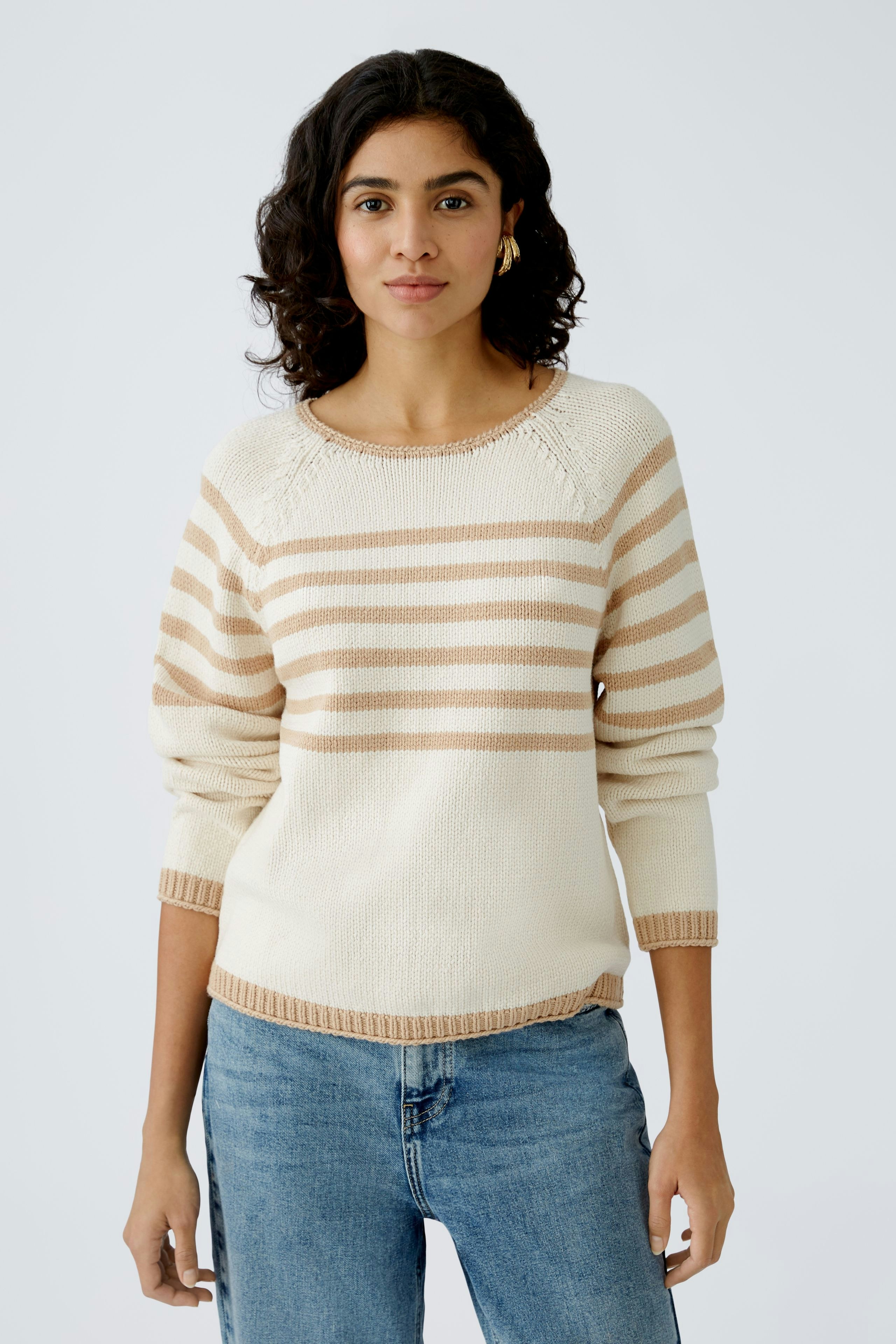 Damen-Pullover: Frau in gestreiftem Pullover in Creme und Beige, lässig und modern.