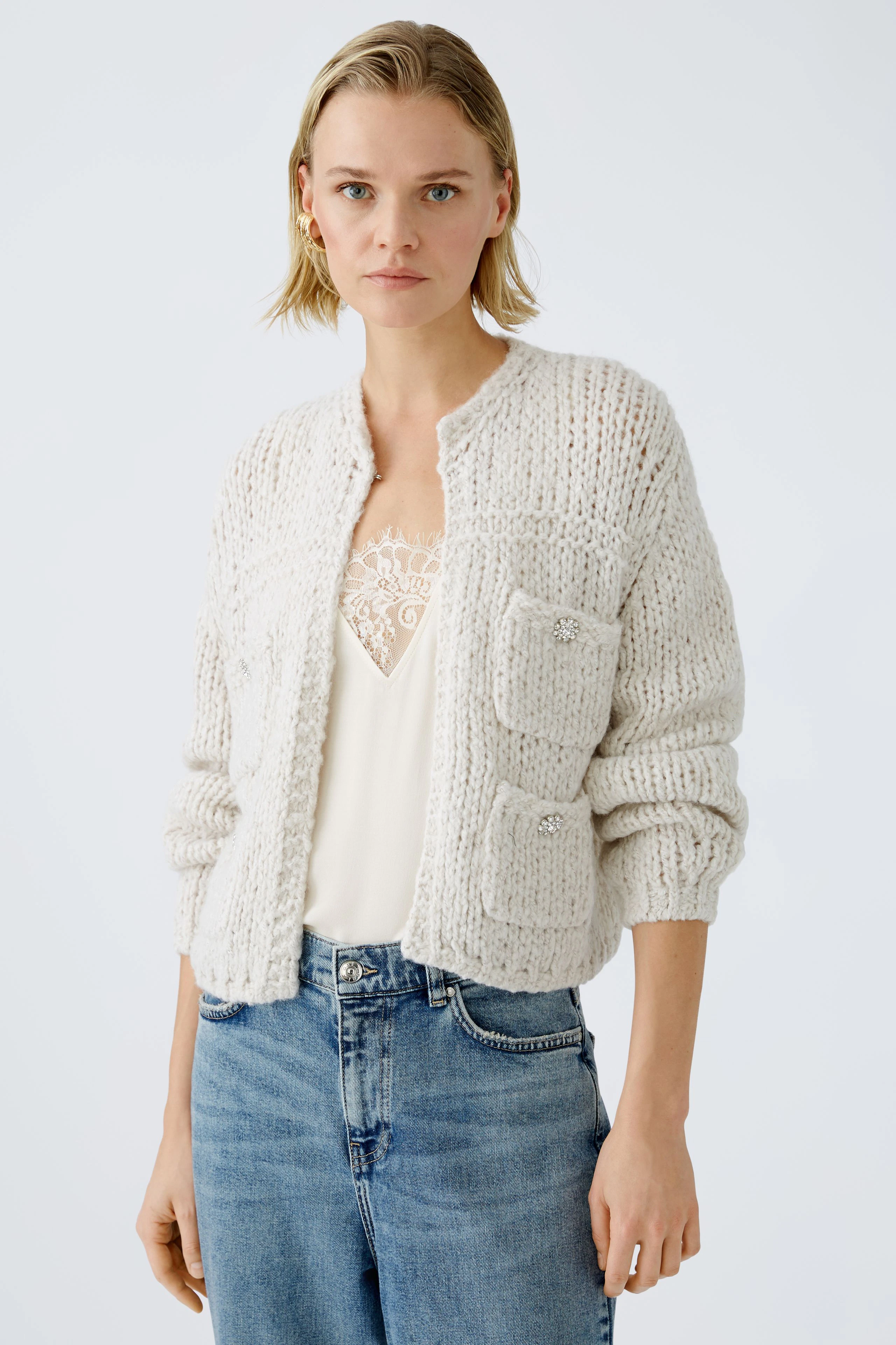 Stylish women's cardigan: A woman in a cozy, light-colored knitted cardigan with pockets.