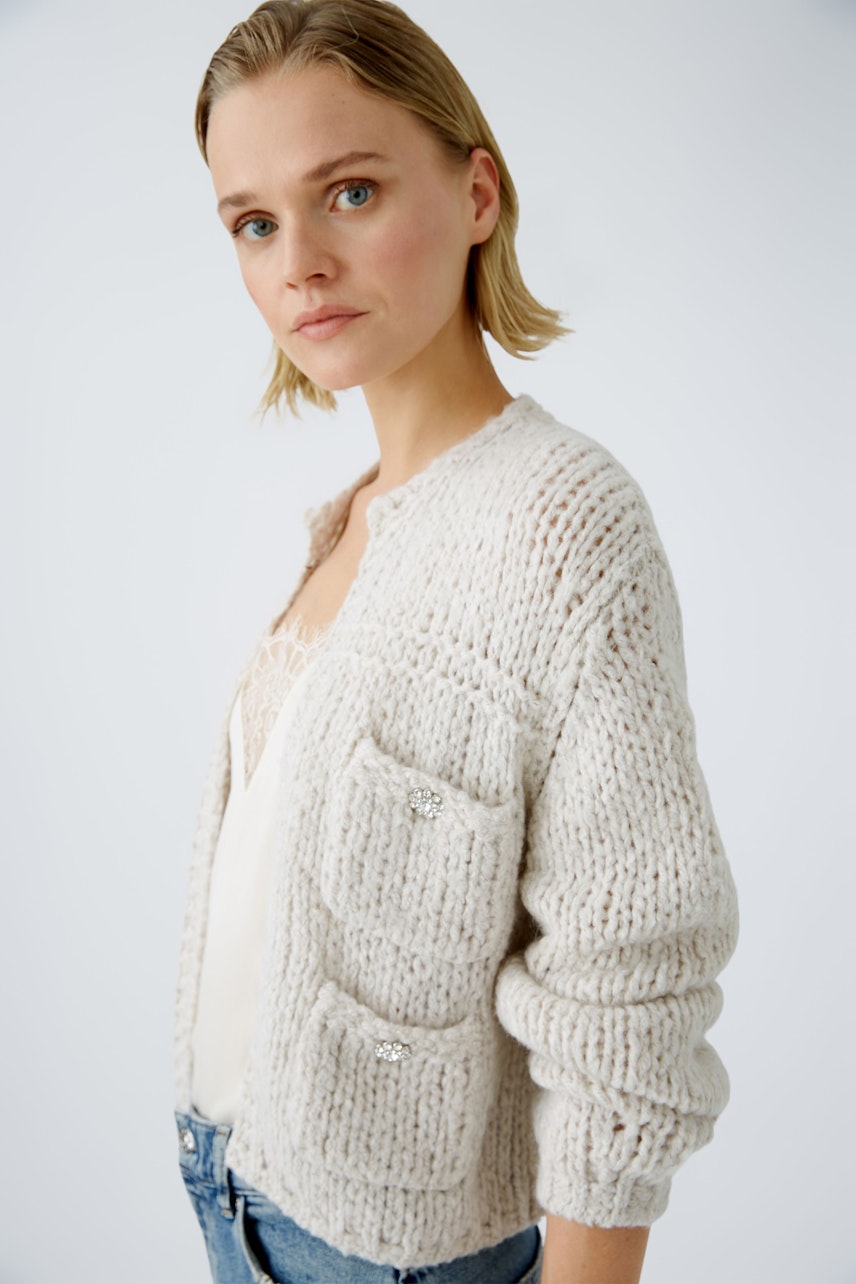 Stylish women's cardigan: A woman in a cozy, light-colored cardigan with pockets, exuding effortless elegance.