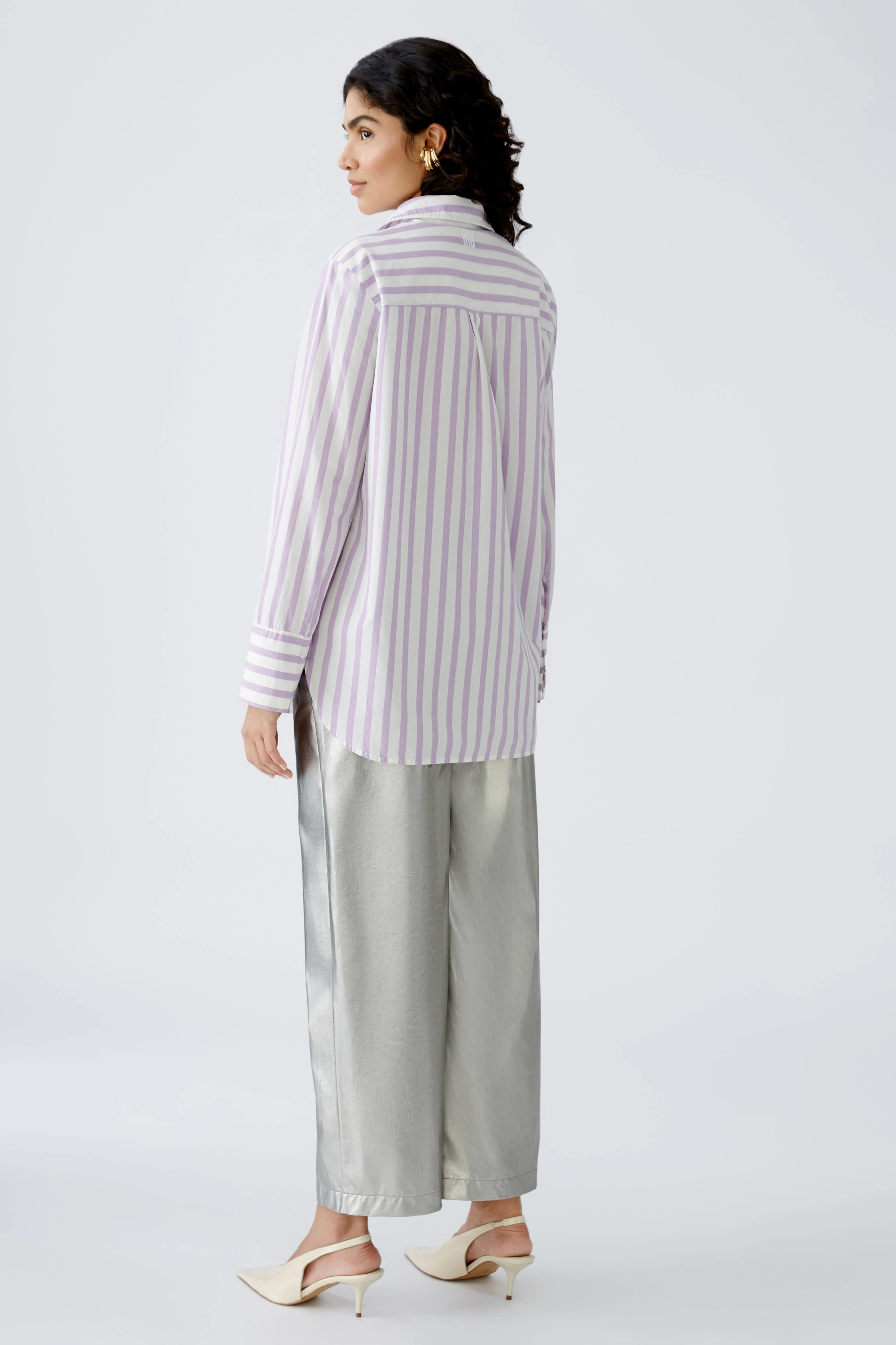 Elegante Damen-Bluse mit lila-weißen Streifen, lässig kombiniert mit silberner Hose.