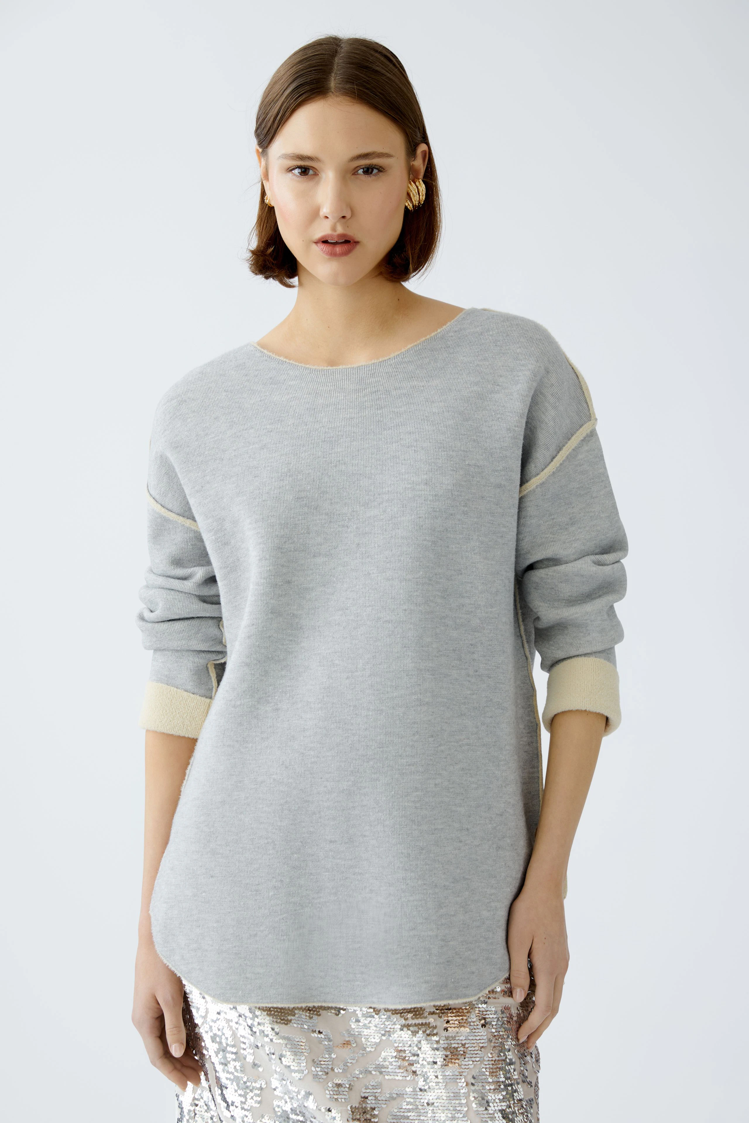 Damen-Pullover: Frau in grauem Pullover mit hellen Akzenten, lässig und modern.