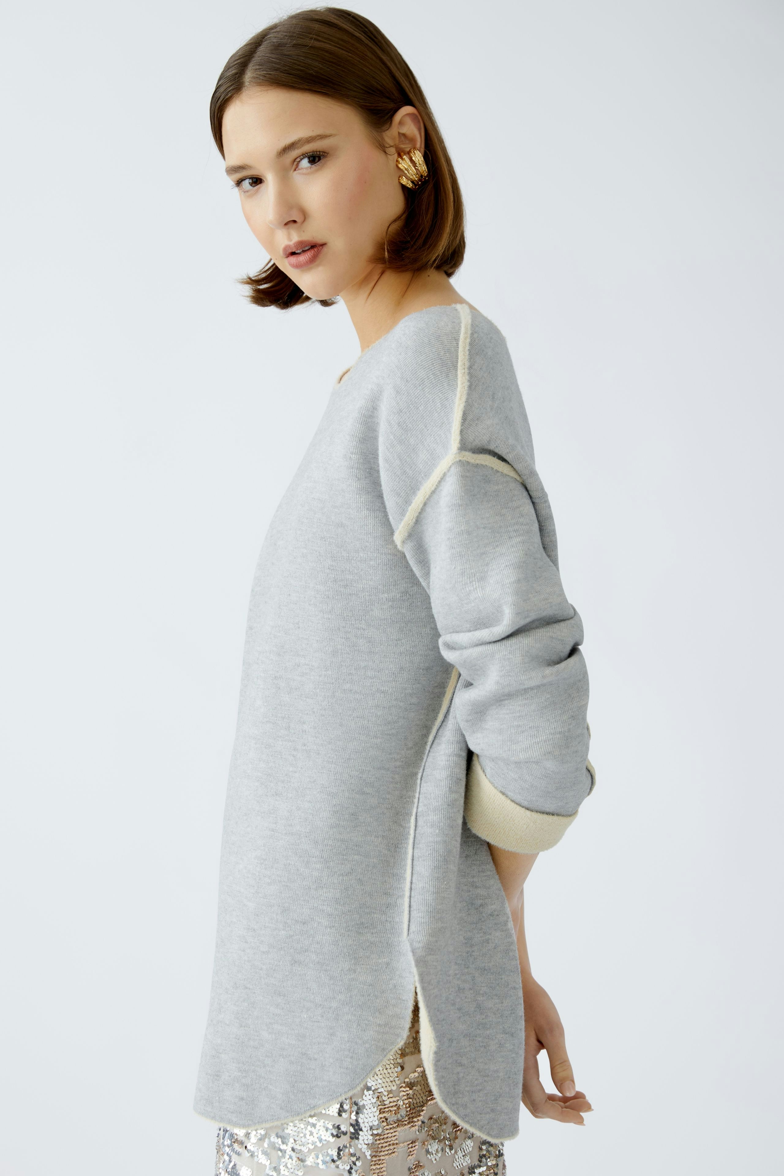 Stylish women's pullover: A woman in a light gray pullover with contrasting details, exuding casual elegance.
