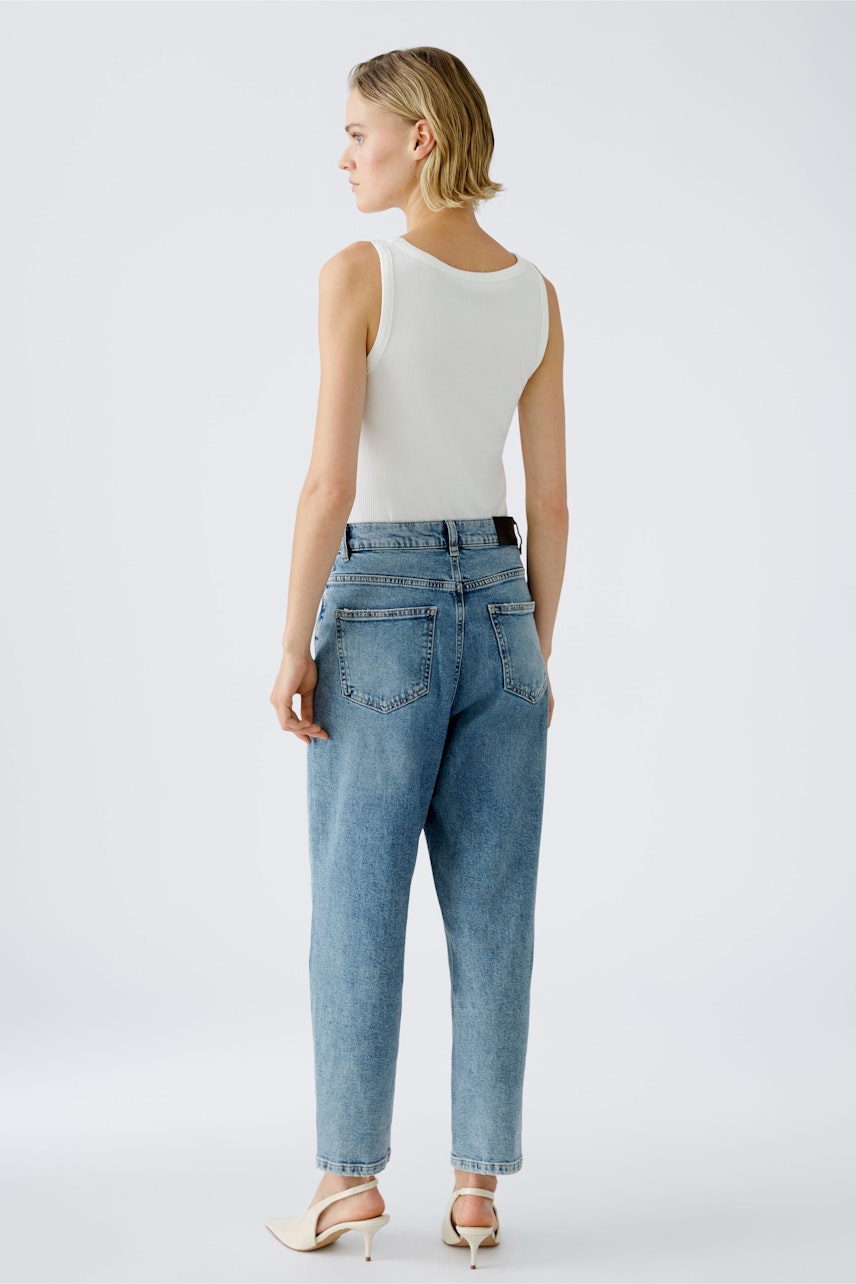 Stylish 5-pocket trousers: Woman in light blue jeans with a relaxed fit, showcasing a modern look.