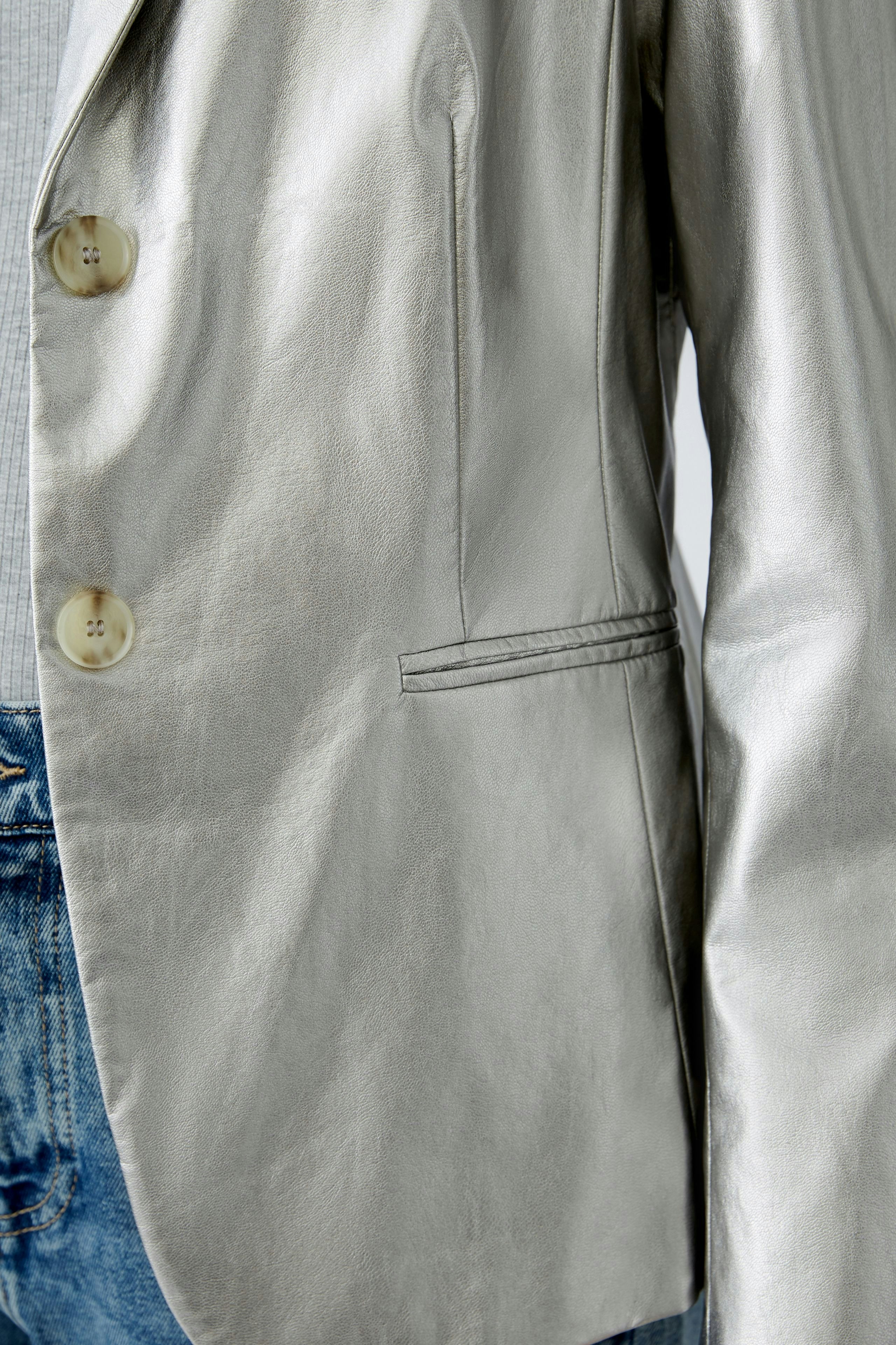 Stylish women's blazer in metallic silver, featuring a sleek design and elegant buttons.