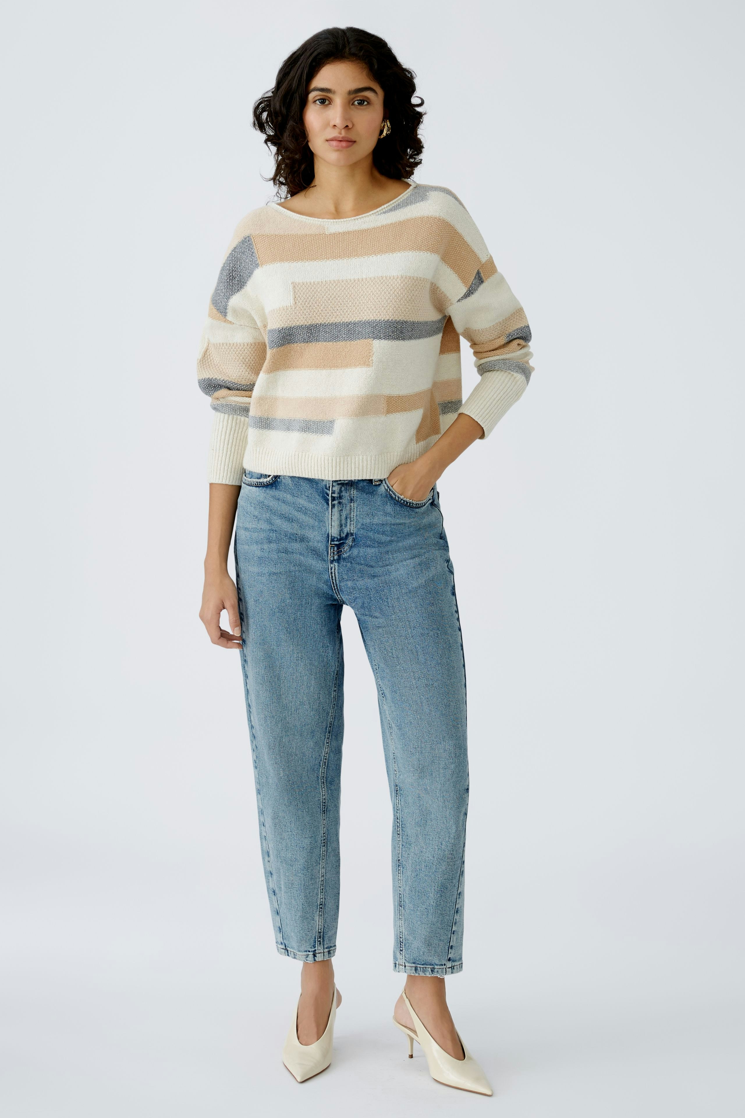 Stylish women's pullover: A woman in a striped pullover paired with jeans, exuding casual elegance.