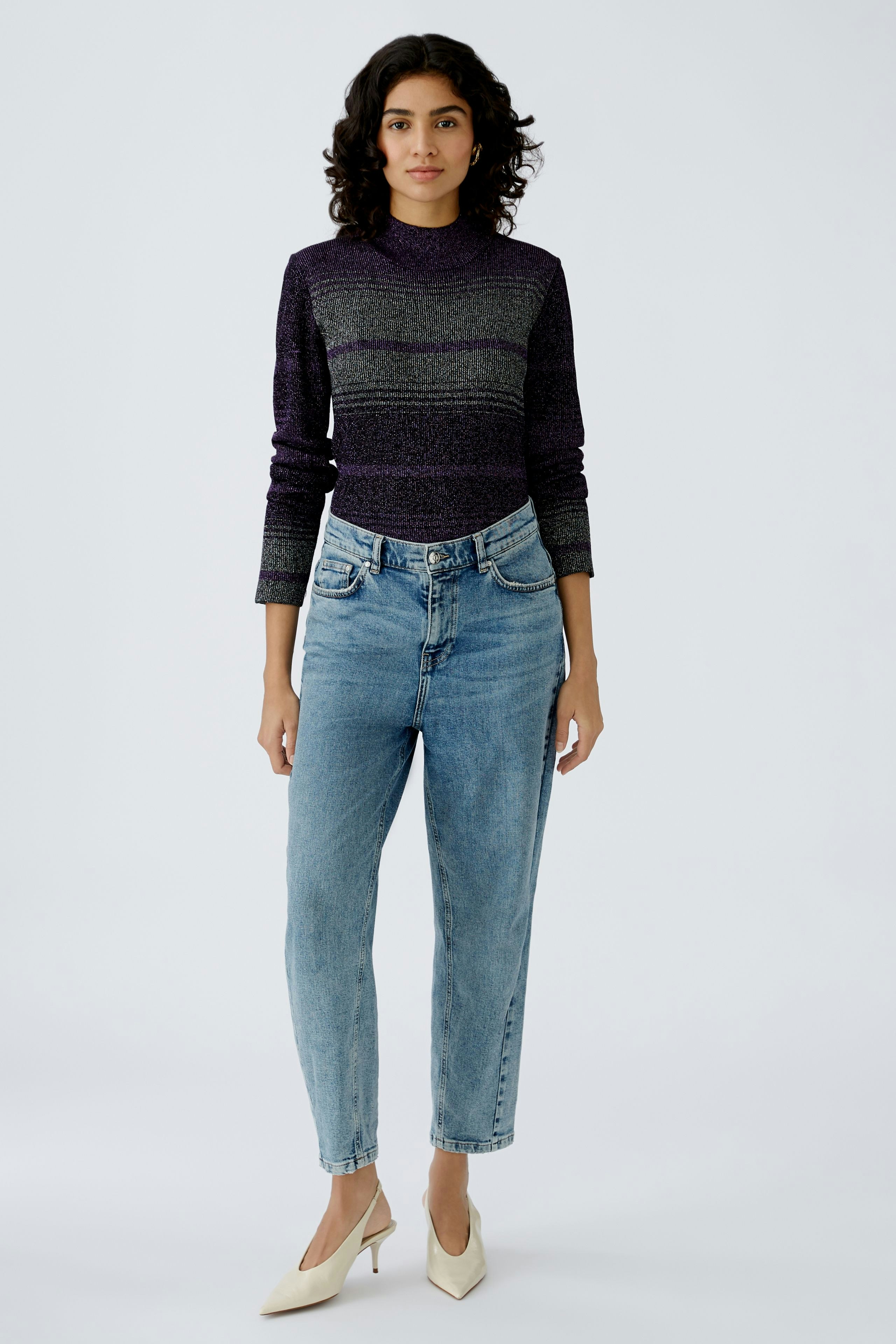 Stylish women's pullover in purple and gray stripes, paired with light blue jeans.