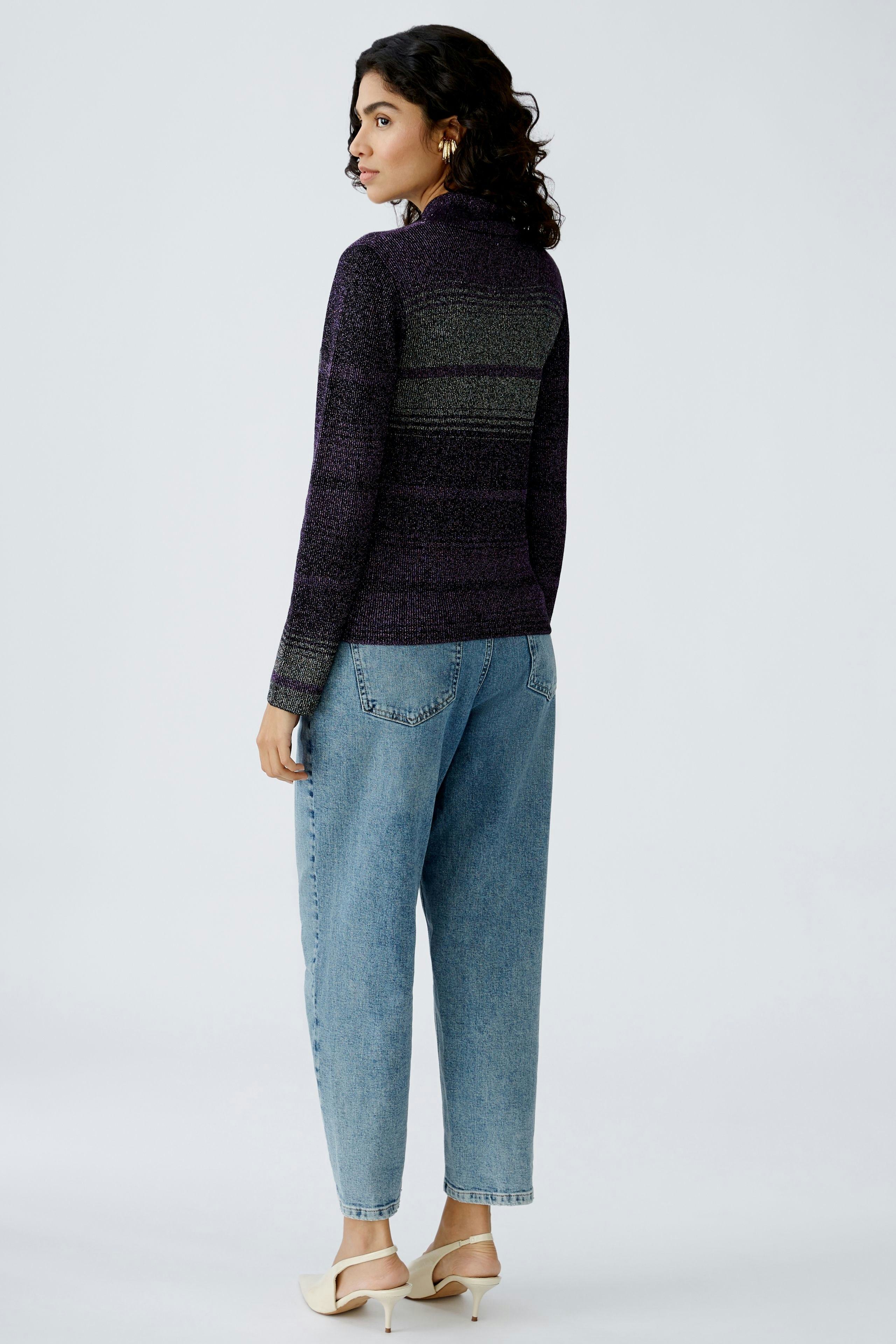 Stylish women's pullover: A woman in a striped purple pullover paired with relaxed jeans.