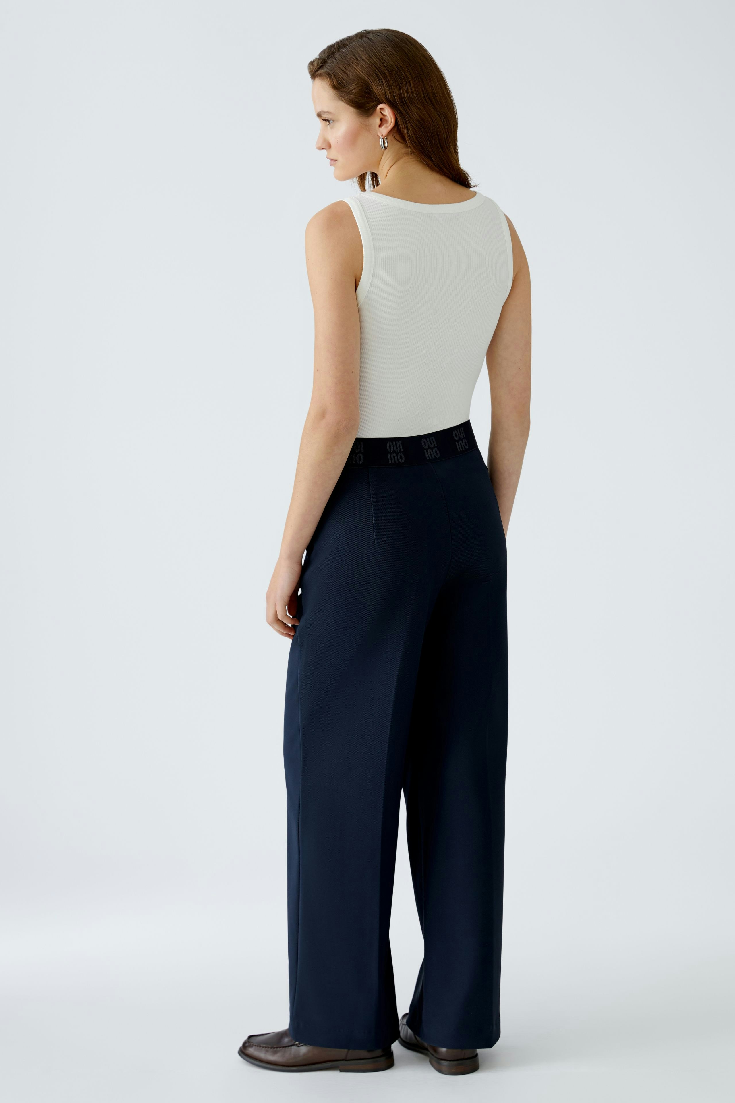 Elegant women's trousers: A woman in navy wide-leg trousers with a fitted waistband, showcasing a chic silhouette.