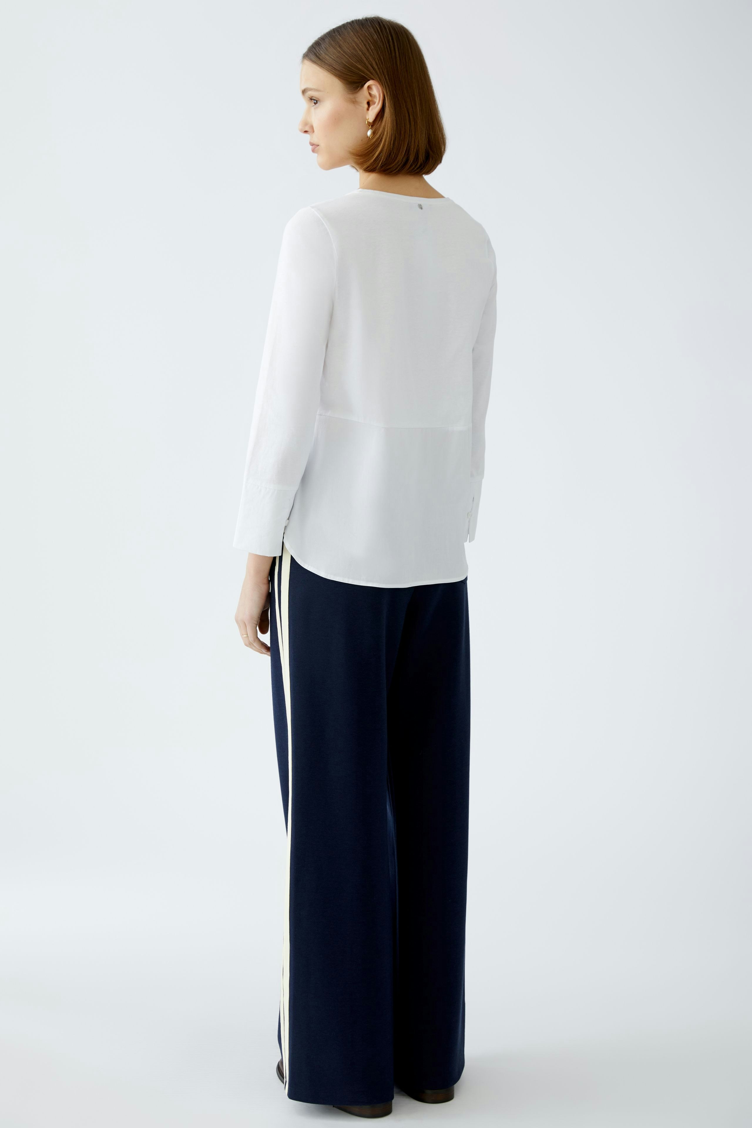 Elegant women's blouse shirt in white, paired with stylish navy wide-leg trousers.