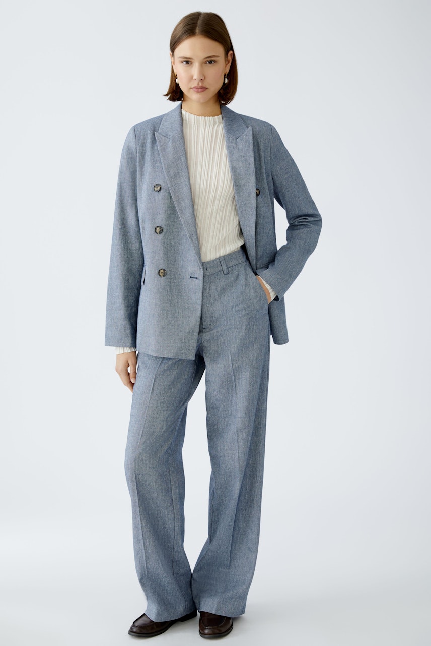 Chic women's trousers: A woman in tailored blue fabric trousers paired with a stylish blazer.