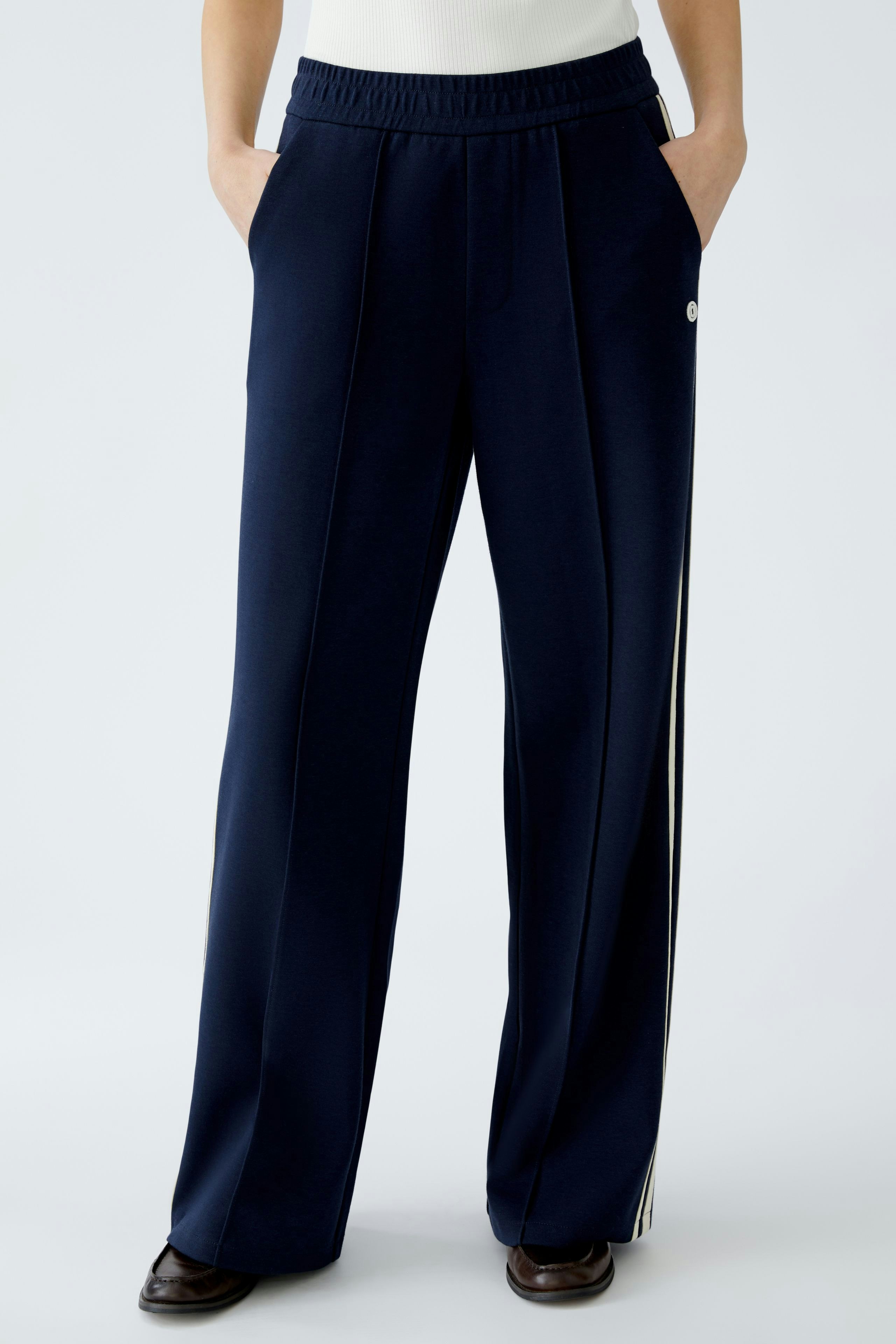 Stylish women's pants: A woman in navy wide-leg pants with side stripes and pockets.