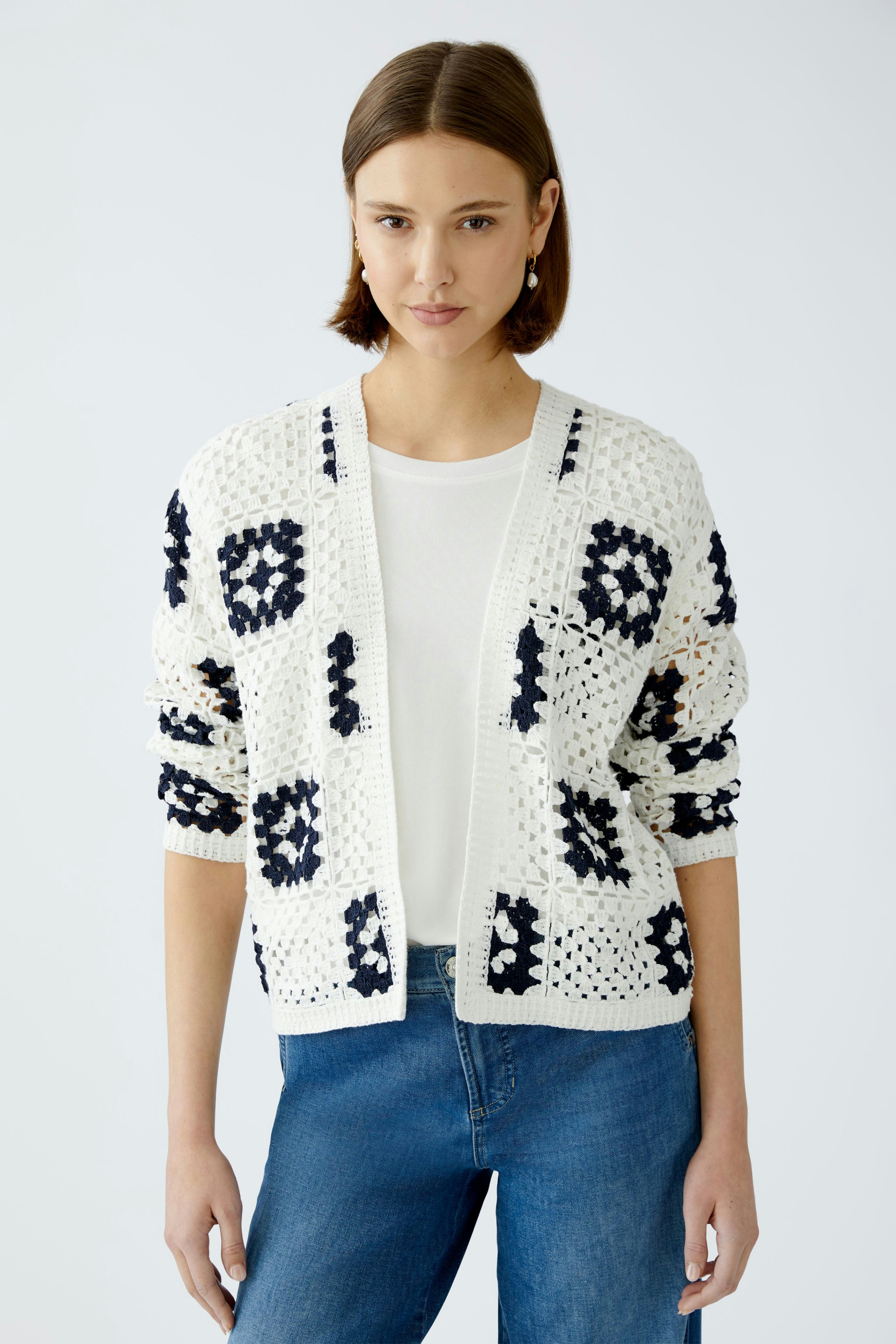 Stylish women's cardigan: A woman in a white and navy patterned cardigan over a simple top.