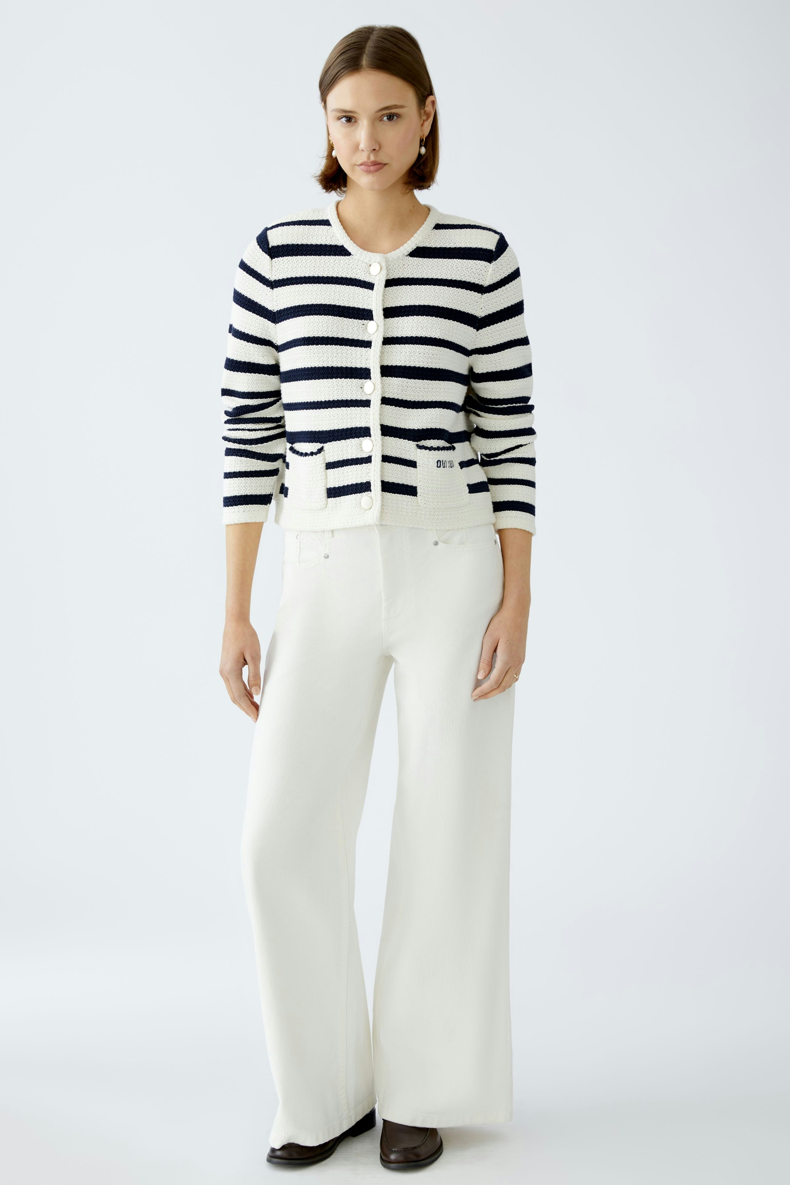 Stylish women's cardigan: A woman in a striped cardigan with buttons, paired with wide-leg pants.