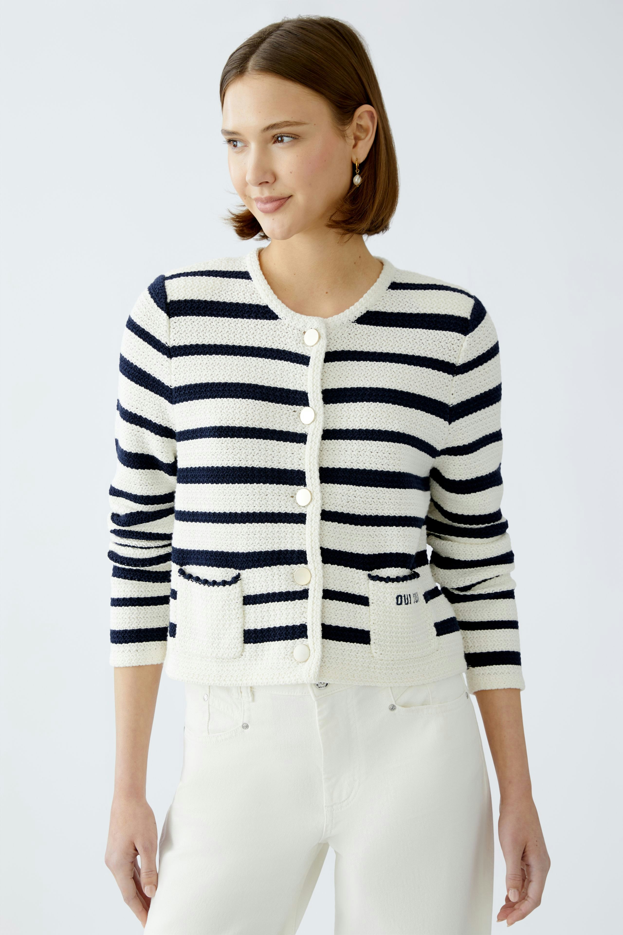 Stylish women's cardigan: A woman in a striped pullover with pockets, exuding casual elegance.