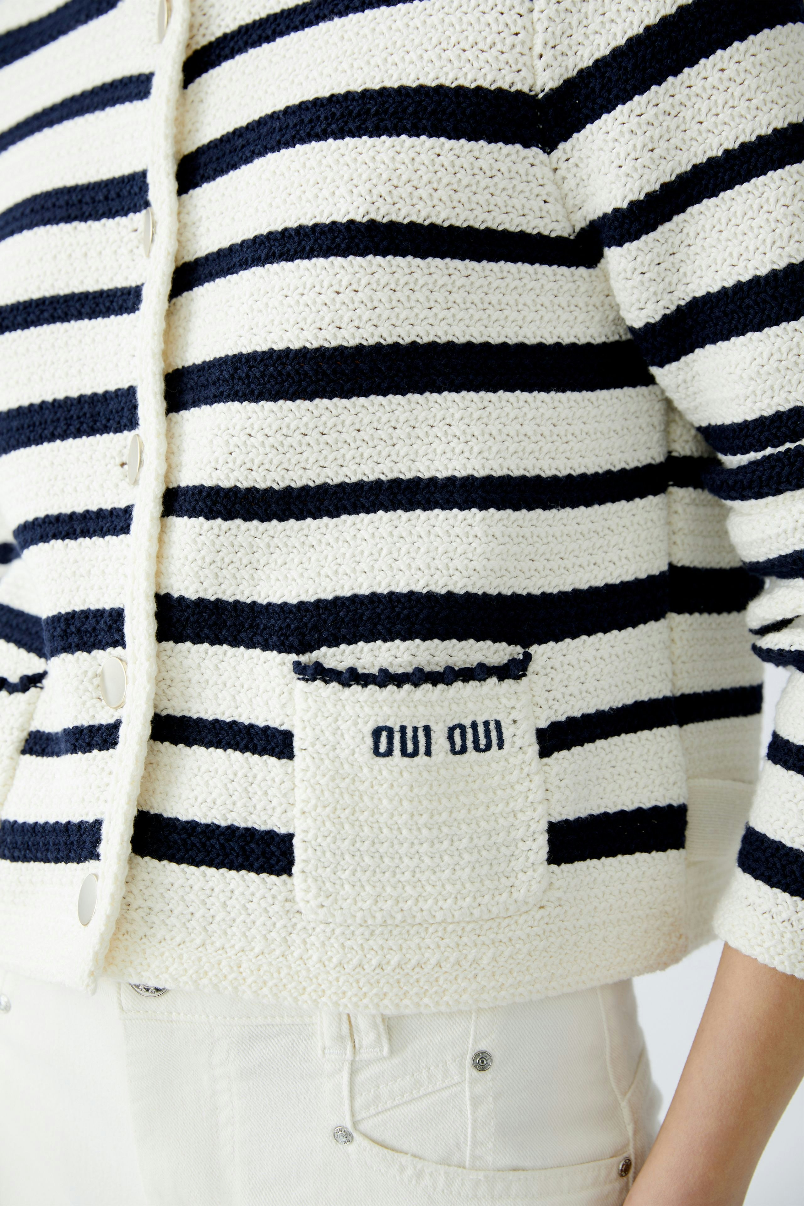 Stylish women's cardigan: A woman in a striped pullover with a pocket detail, perfect for casual wear.