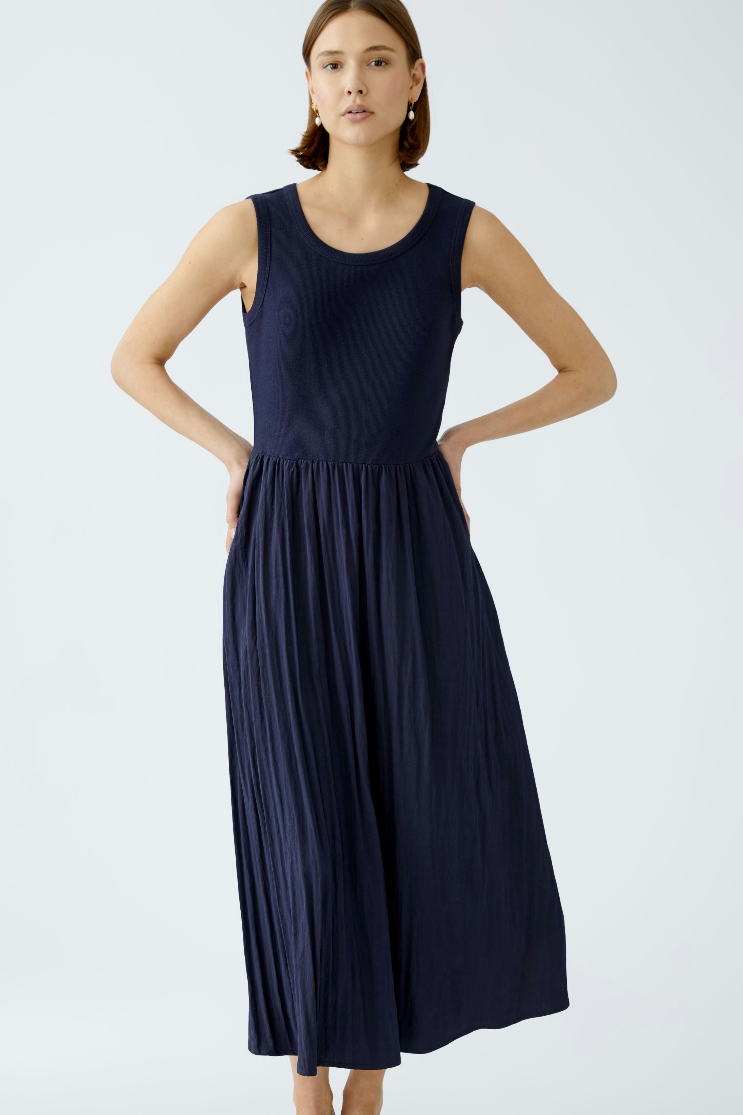 Elegantes Damen-Kleid: Frau in einem ärmellosen, navyblauen Maxikleid mit fließendem Rock.