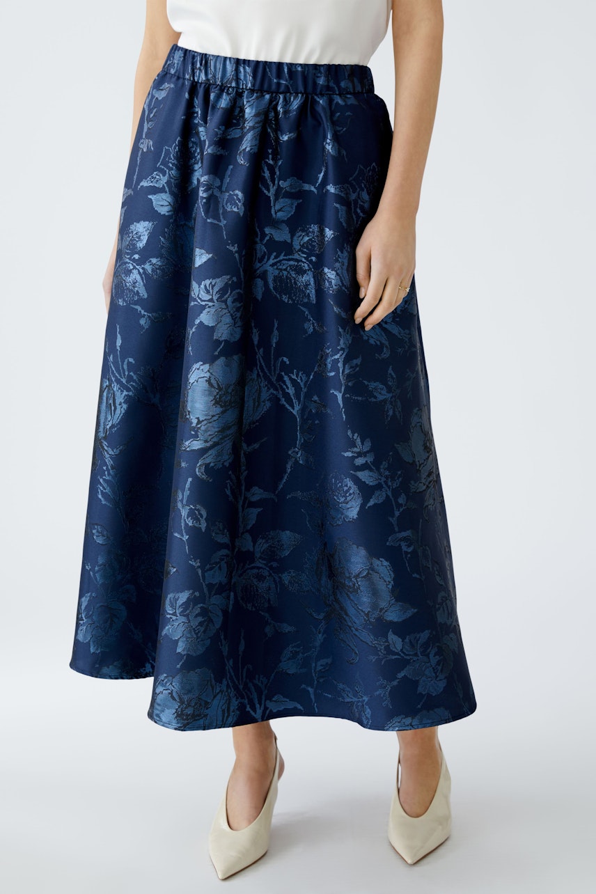 Elegant maxi skirt: Woman in a navy floral skirt with an elastic waistband, perfect for any occasion.