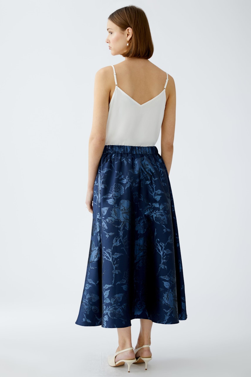 Elegant maxi skirt: A woman in a floral navy skirt, showcasing a flowing design and comfortable fit.