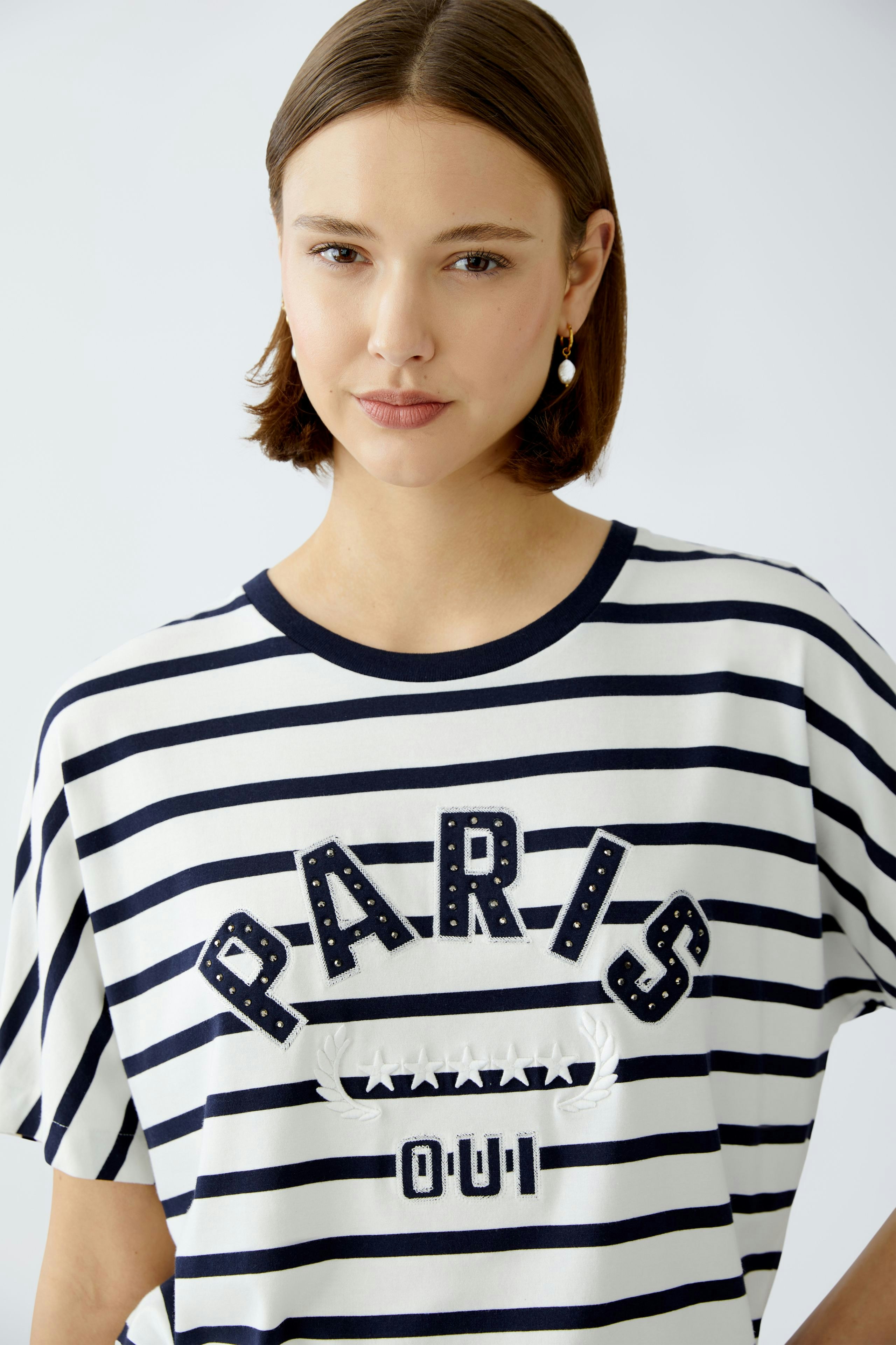 Stylish women's T-shirt: A woman in a striped tee featuring 'PARIS OUI' in bold letters.