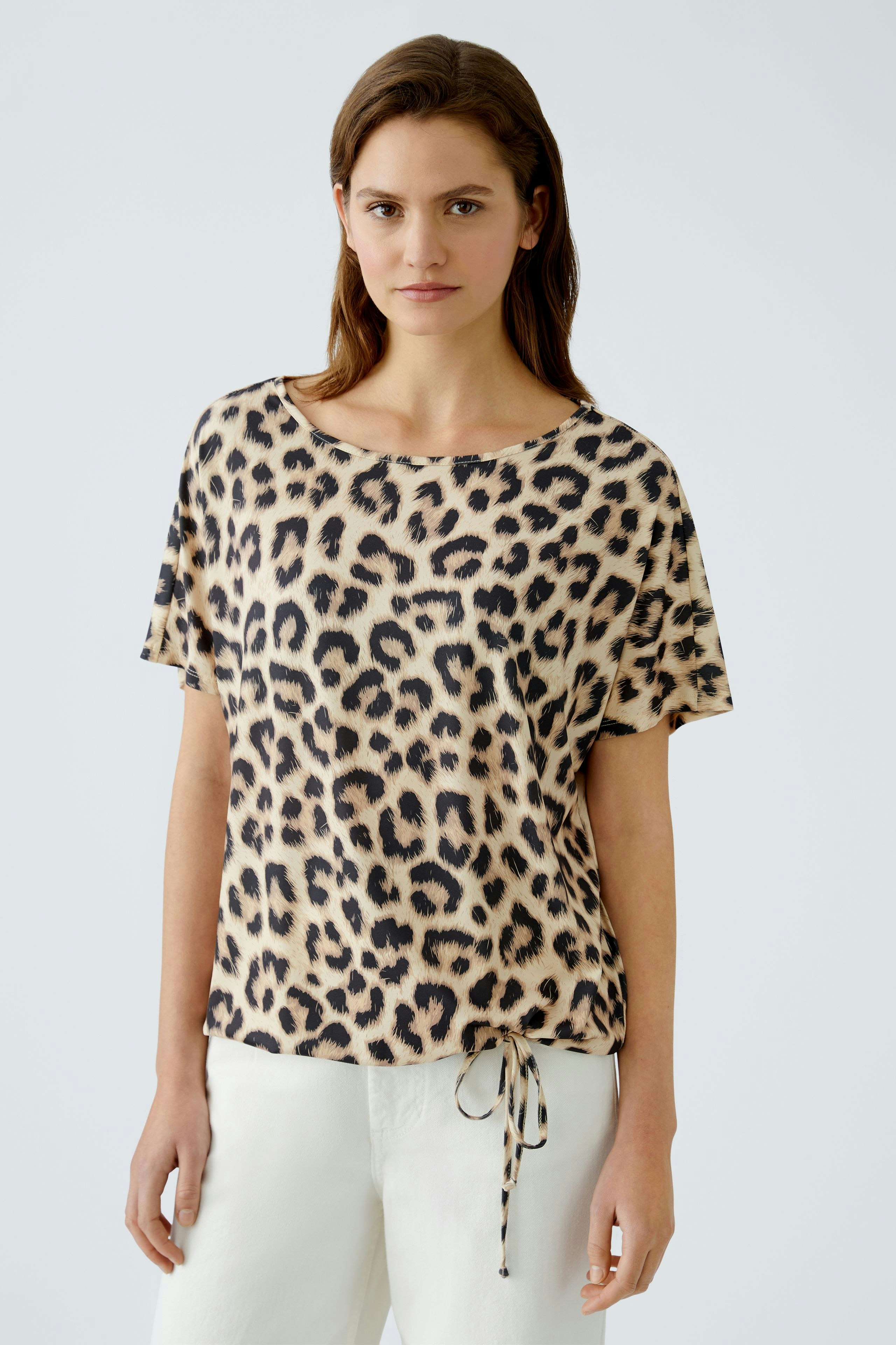 Stylish women's T-shirt: A woman in a leopard print top with a relaxed fit and drawstring detail.